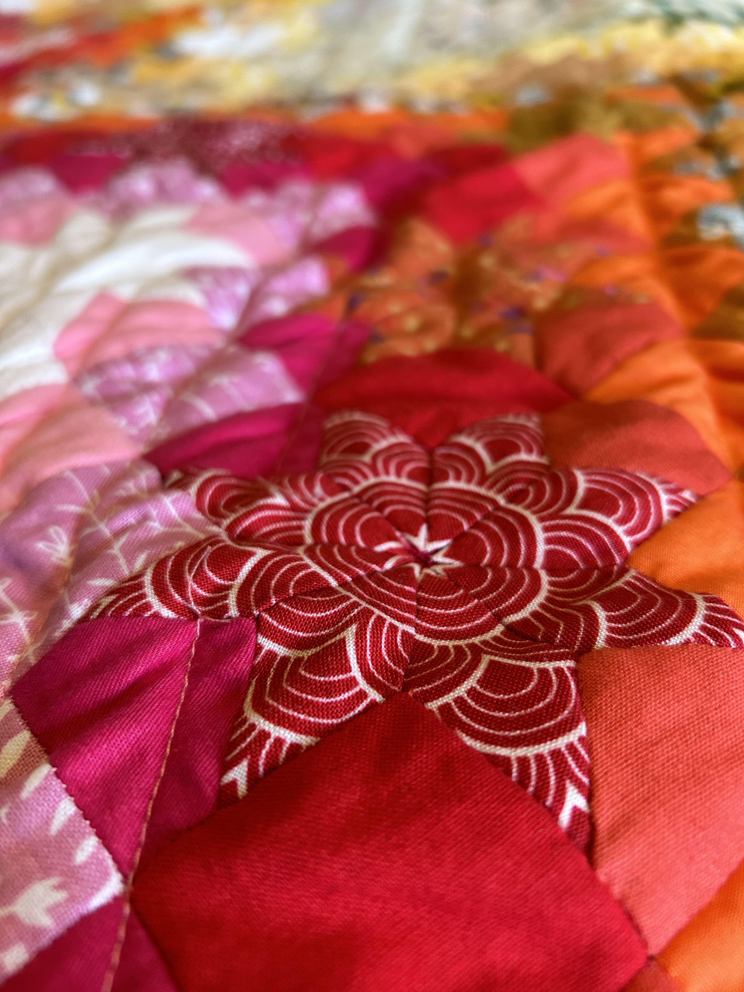 close up detail of epp star on a bed quilt