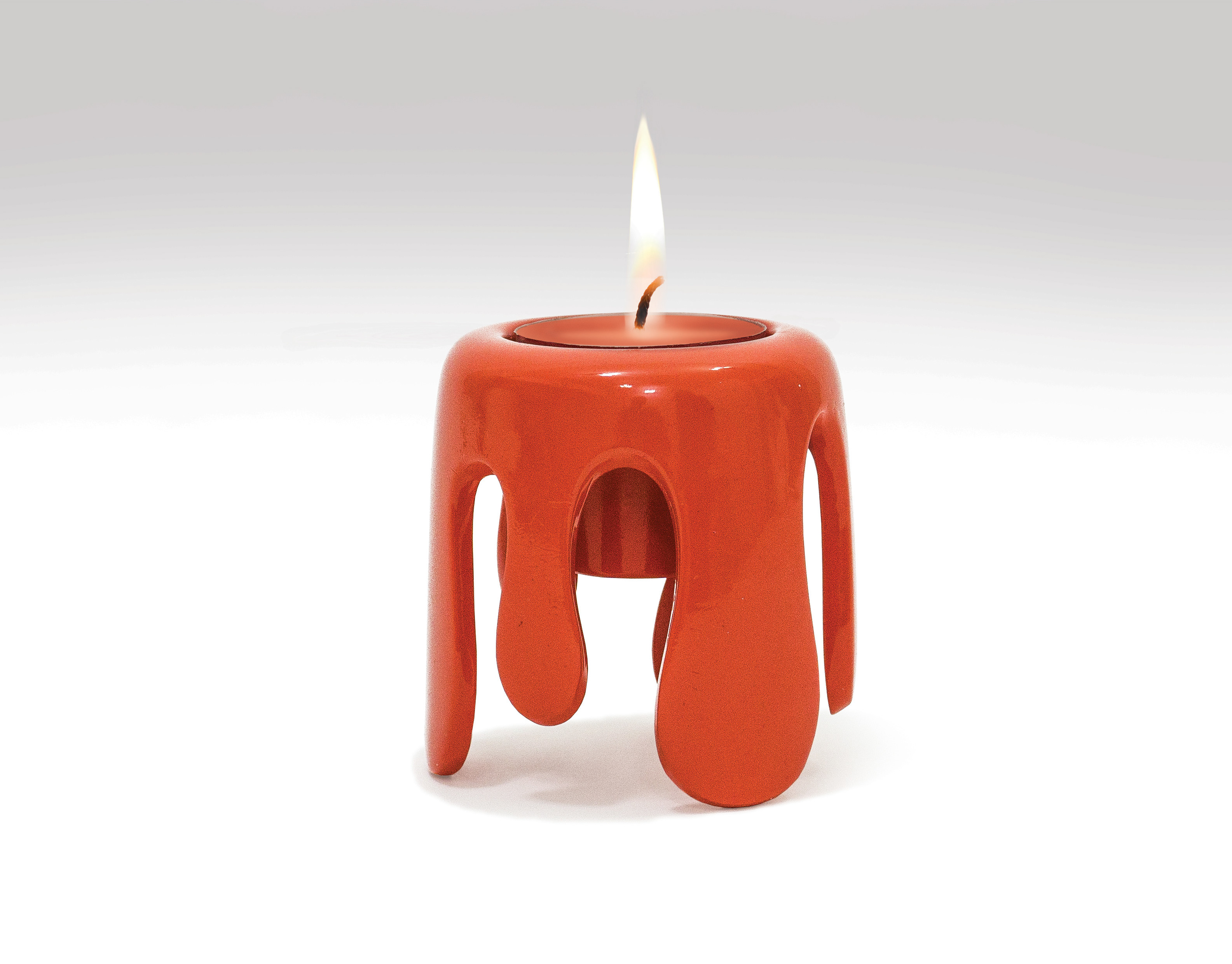 Burning candle with melting wax dripping over a candle hol…