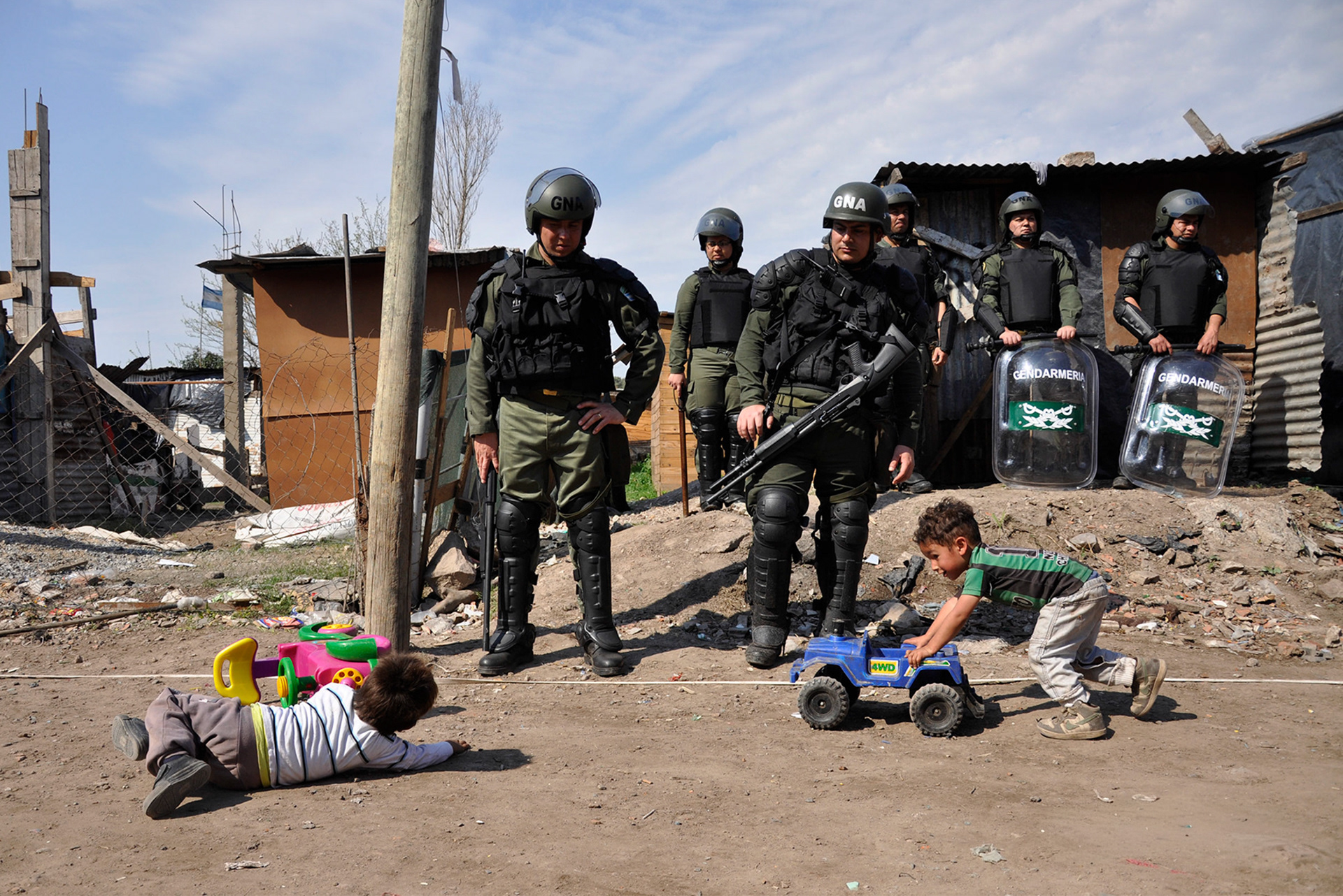 Gendarmes observan a niños jugar durante el violento desalojo de la Villa Papa Francisco