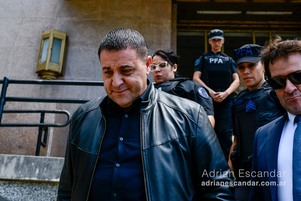 Pablo Toviggino saliendo de los tribunales rodeado de sus abogados y policía.