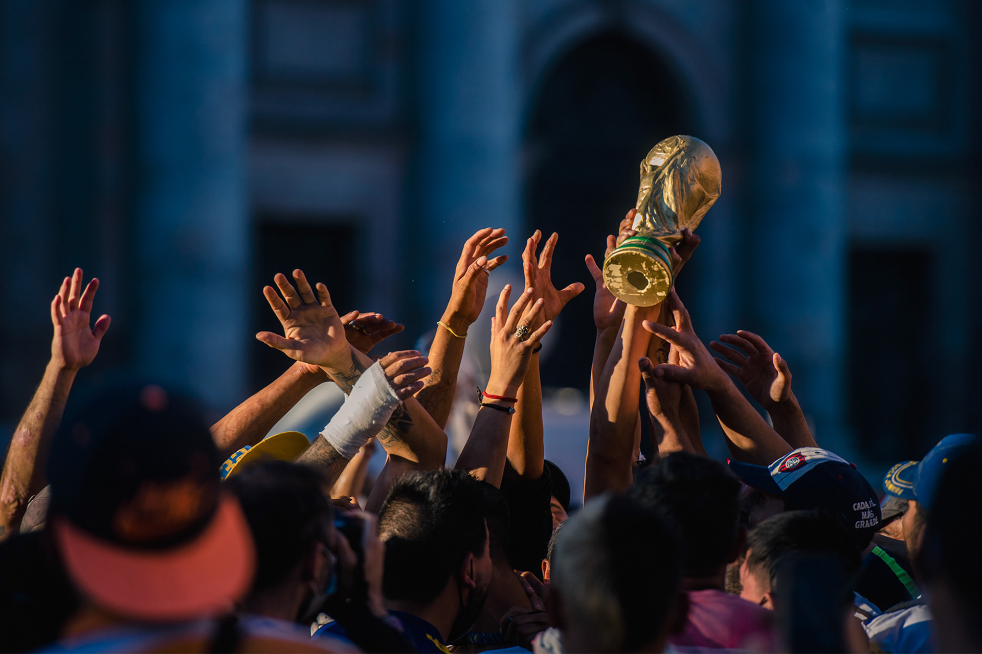 Personas levantan la replica de la copa del mundo durante el velorio de Diego Maradora