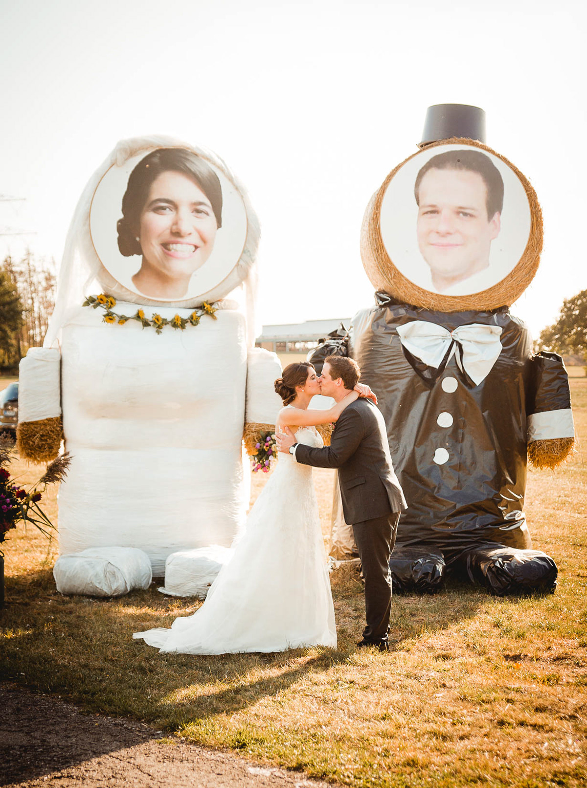 Hochzeitsfoto von Brautpaar vor Stohballenfiguren