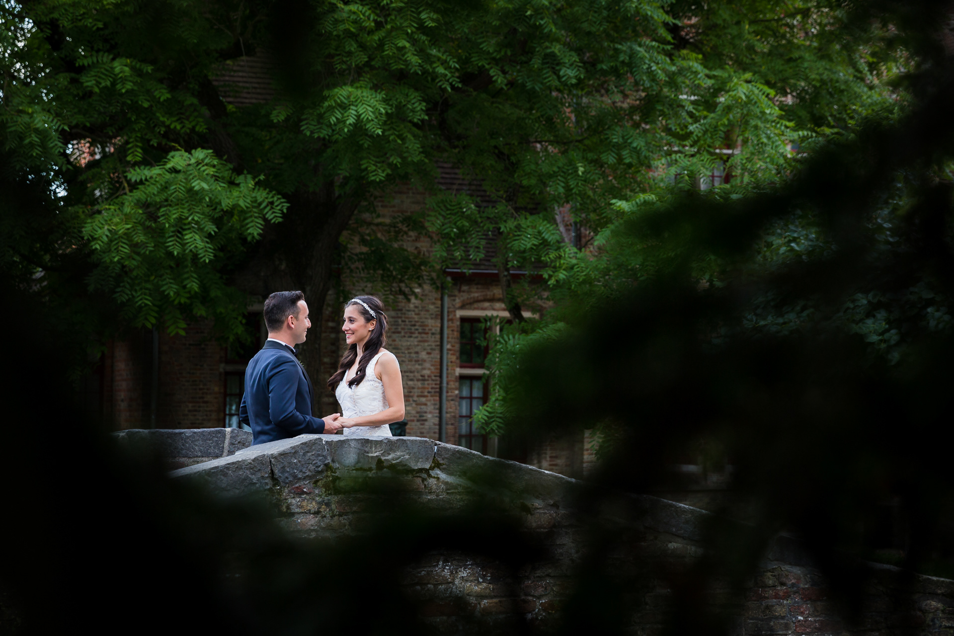 Couple of newly weds on a bridge during a romantic photo shoot in Bruges, Belgium.