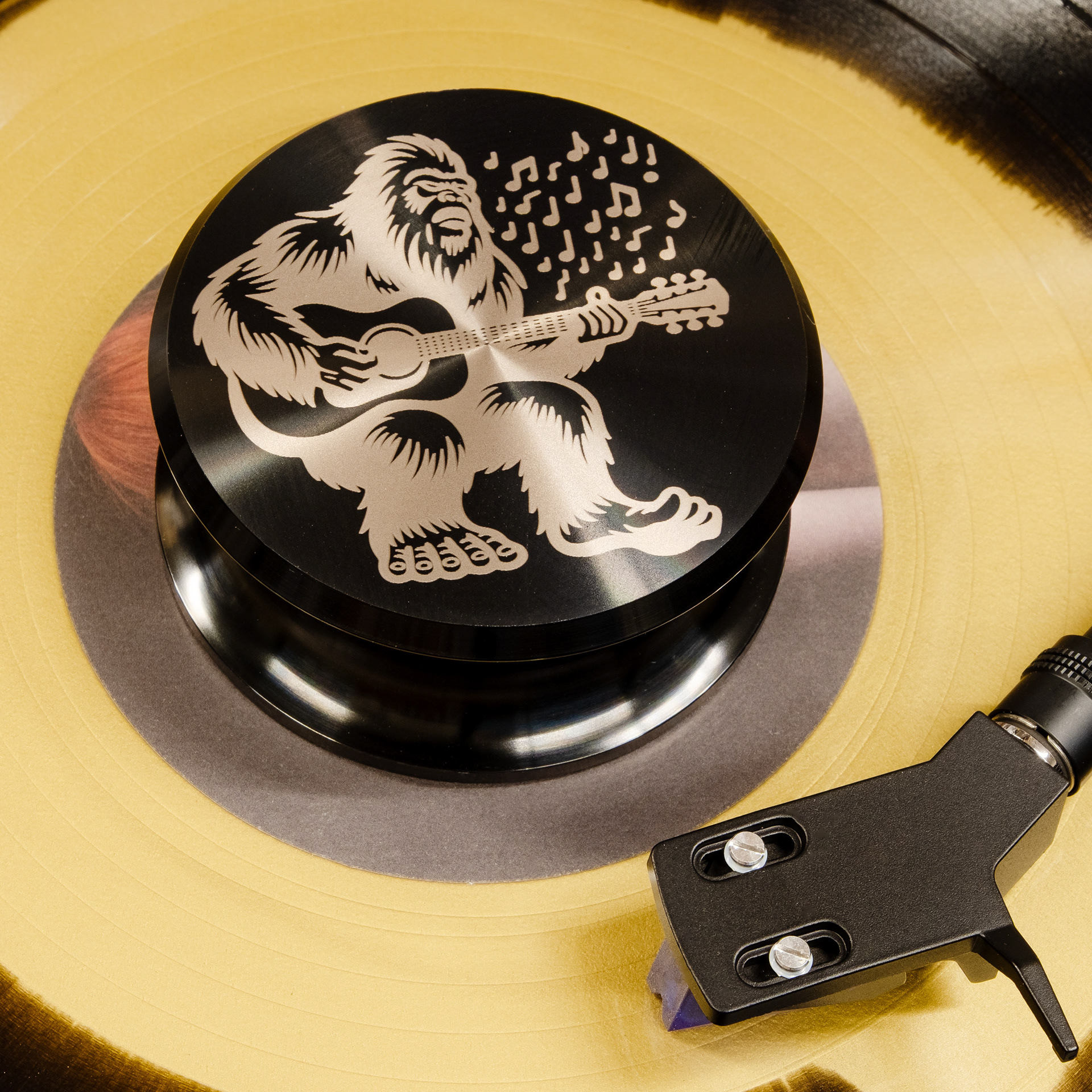 Bigfoot playing guitar engraved aluminum vinyl record weight stabilizer on a yellow record