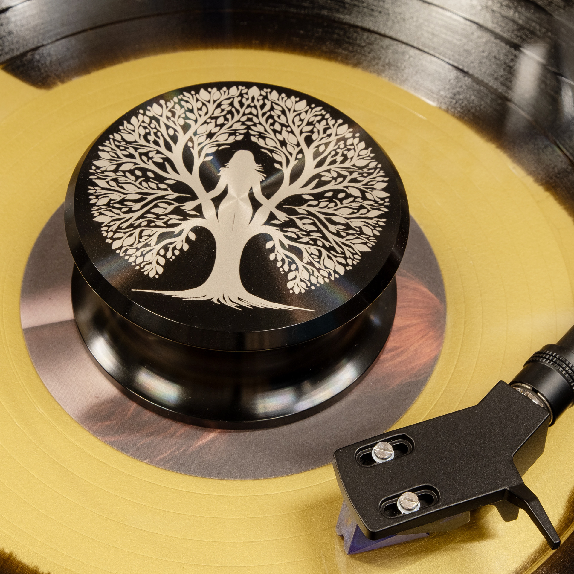Tree of life engraved aluminum vinyl record weight stabilizer on a yellow record