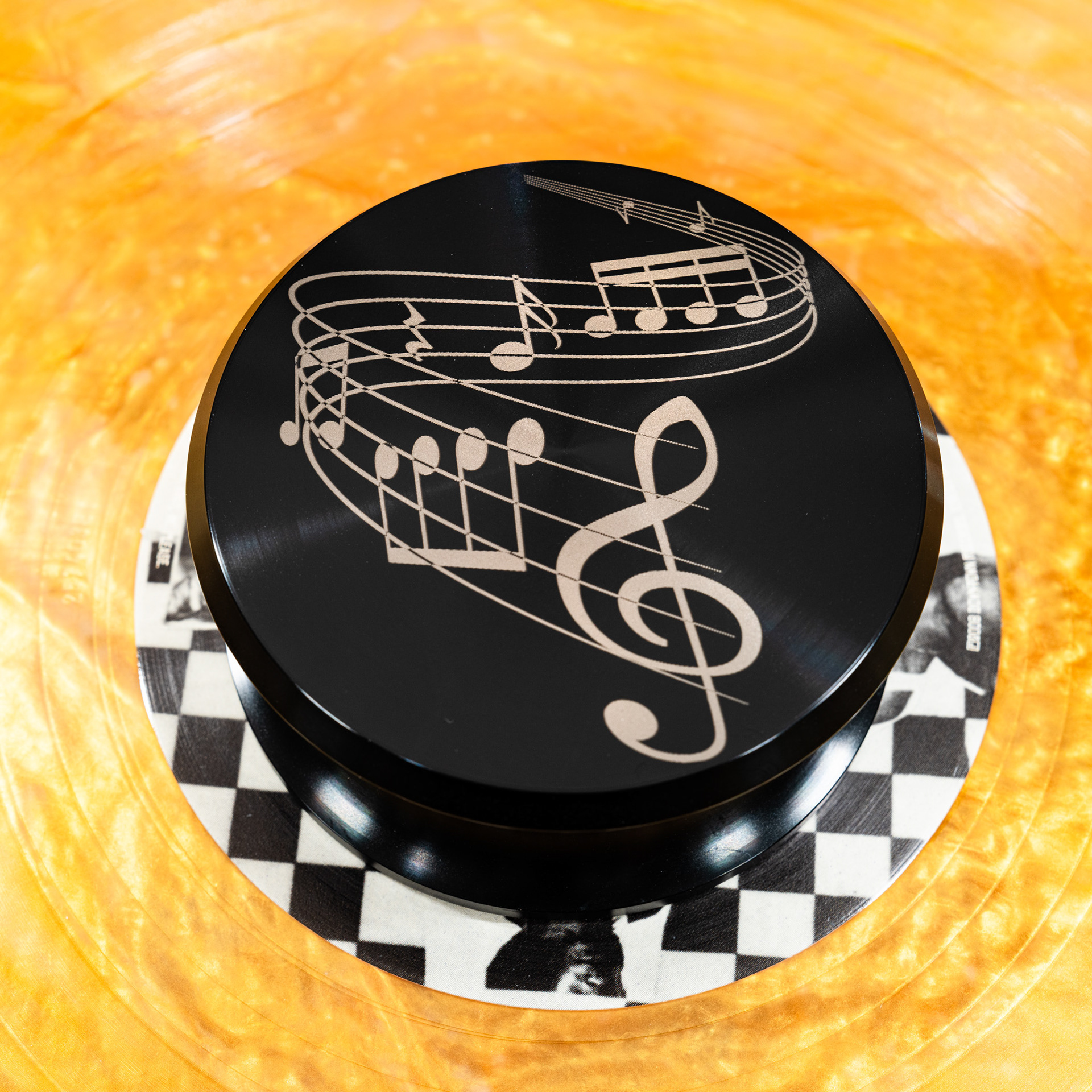 Musical notes and treble clef engraved aluminum record weight stabilizer on yellow vinyl