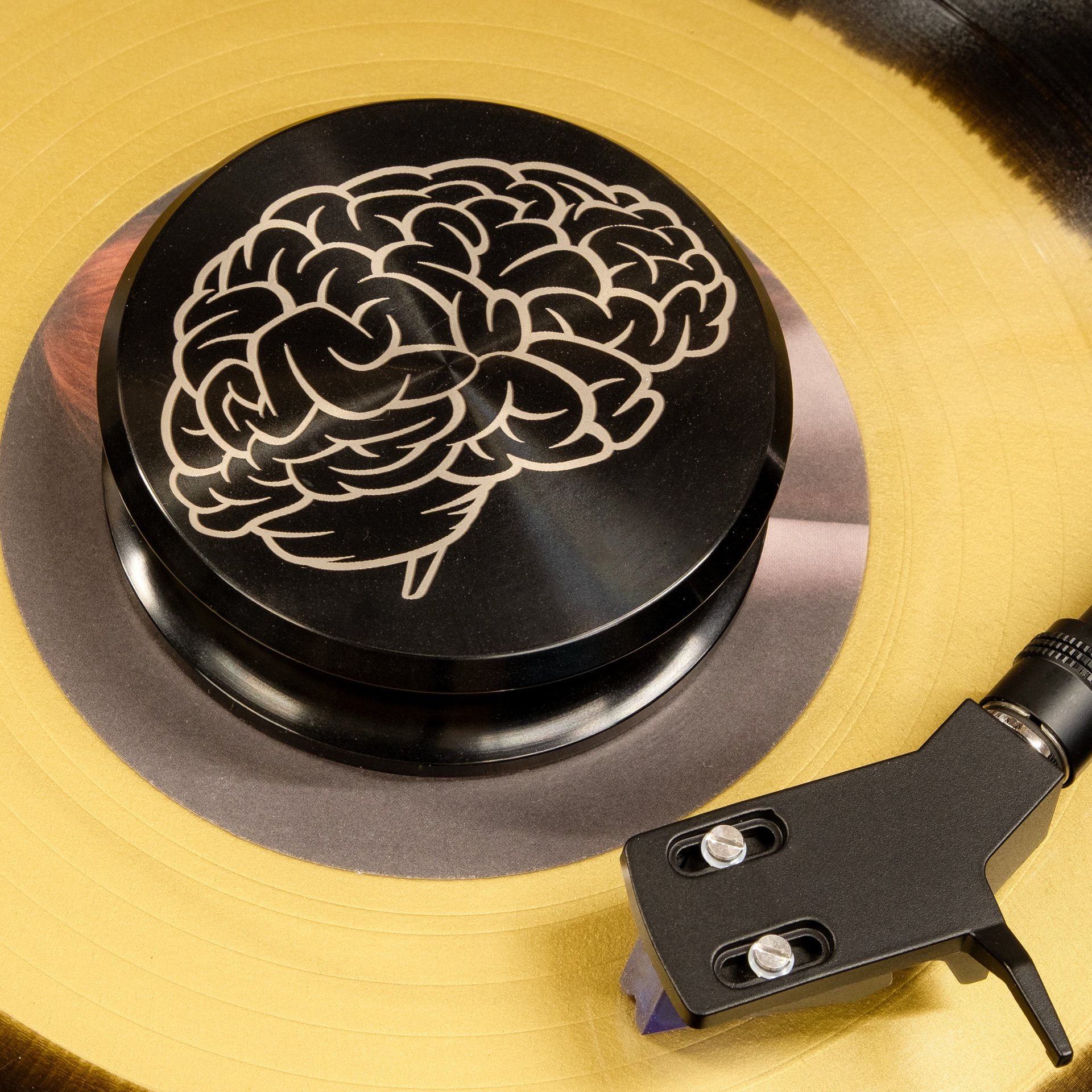 Brain design engraved aluminum vinyl record weight stabilizer on a yellow record
