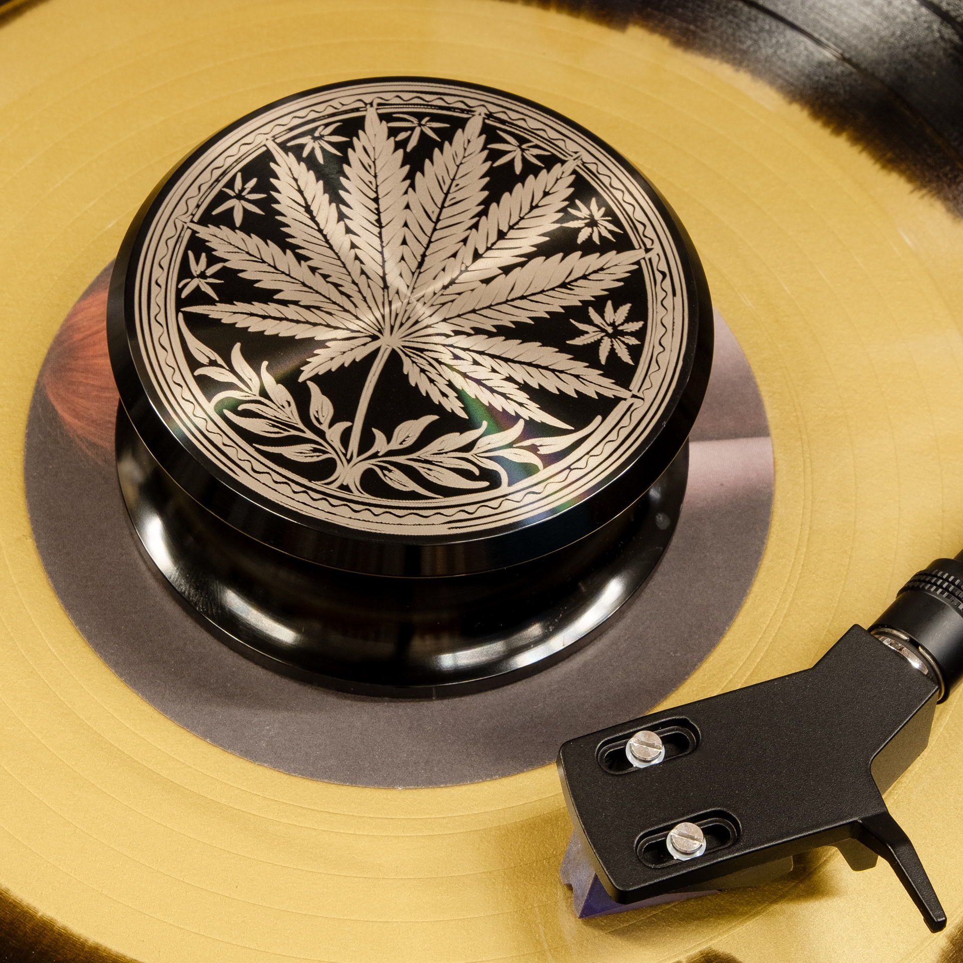 Cannabis leaf engraved aluminum vinyl record weight stabilizer on a yellow record