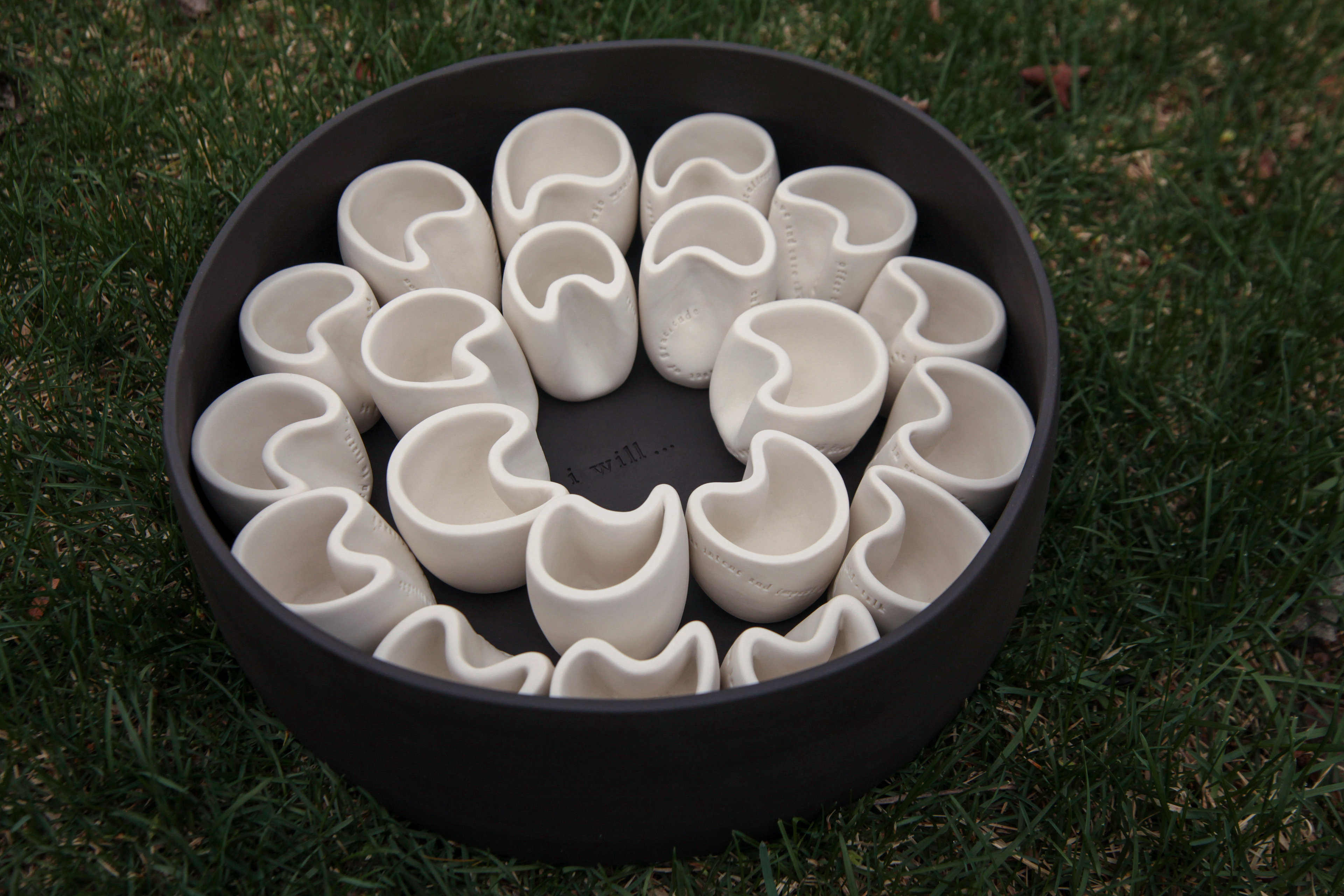 Porcelain cups centered around the statement “I will…” stamped into the carrier | Each cup is stamped with a unique act of kindness