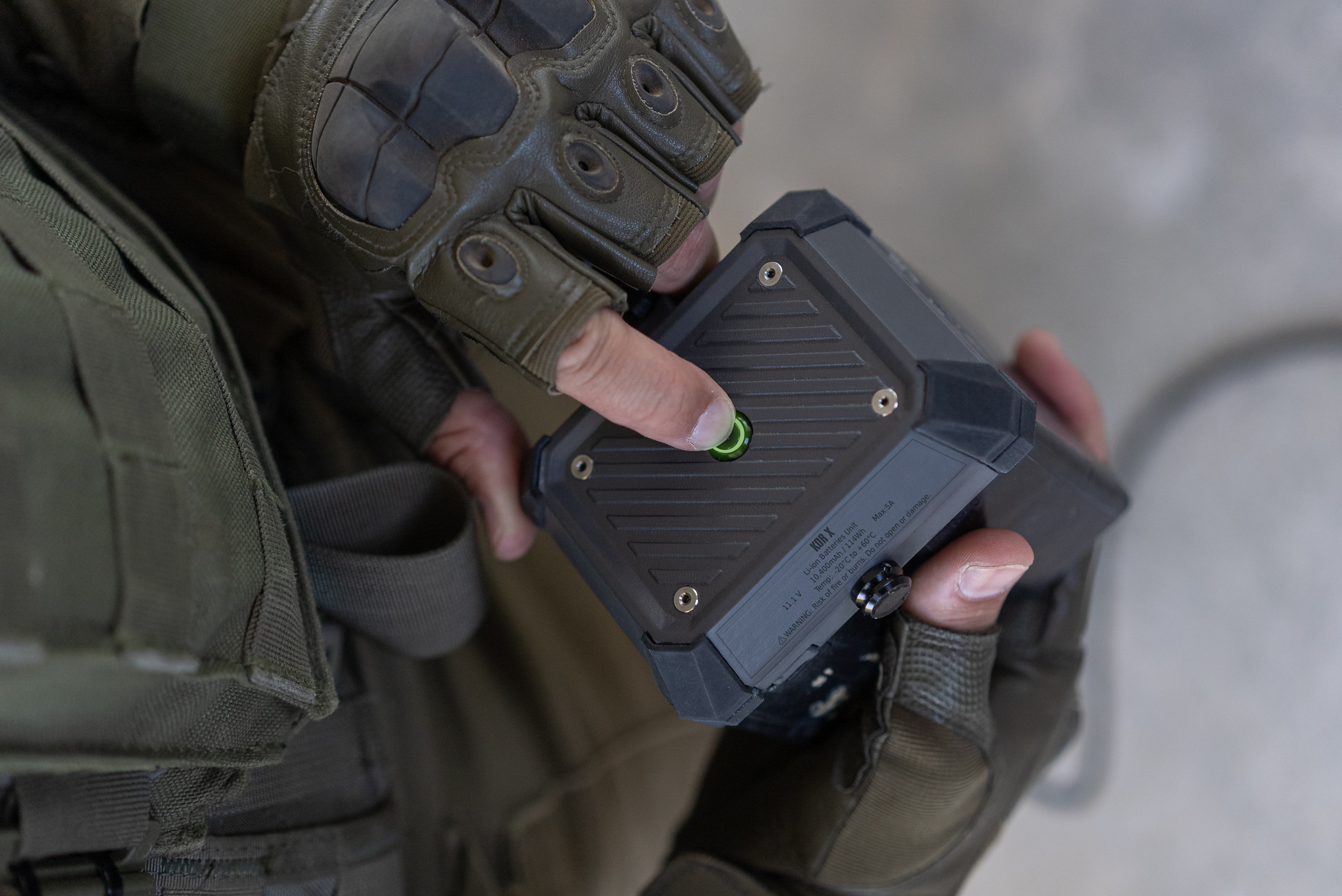 Compact LEDs indicate battery level: green (full), yellow (half), red (low). Visible but small to reduce exposure in the field.