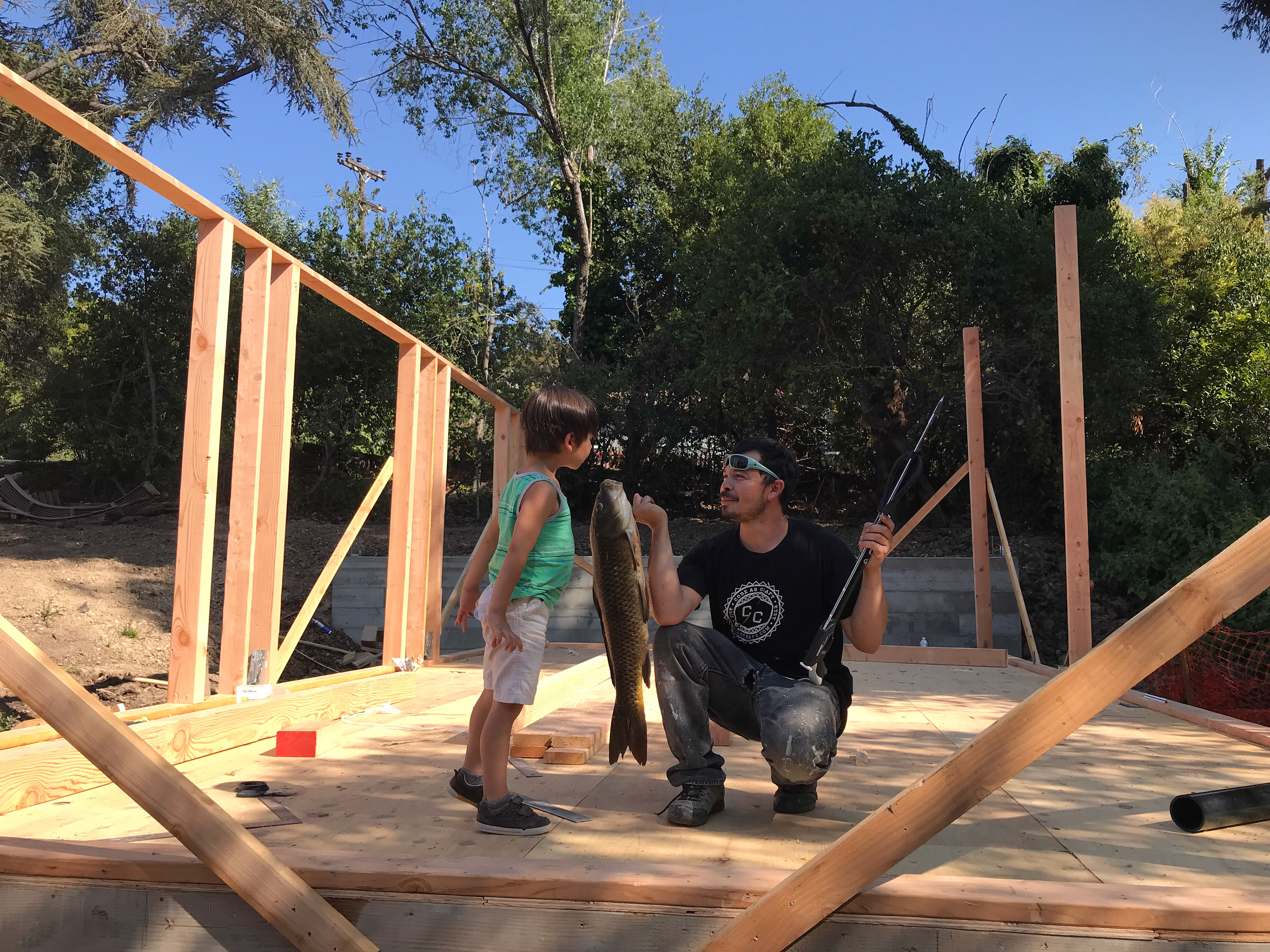Beto shows Solo a big fish he caught in the creek.