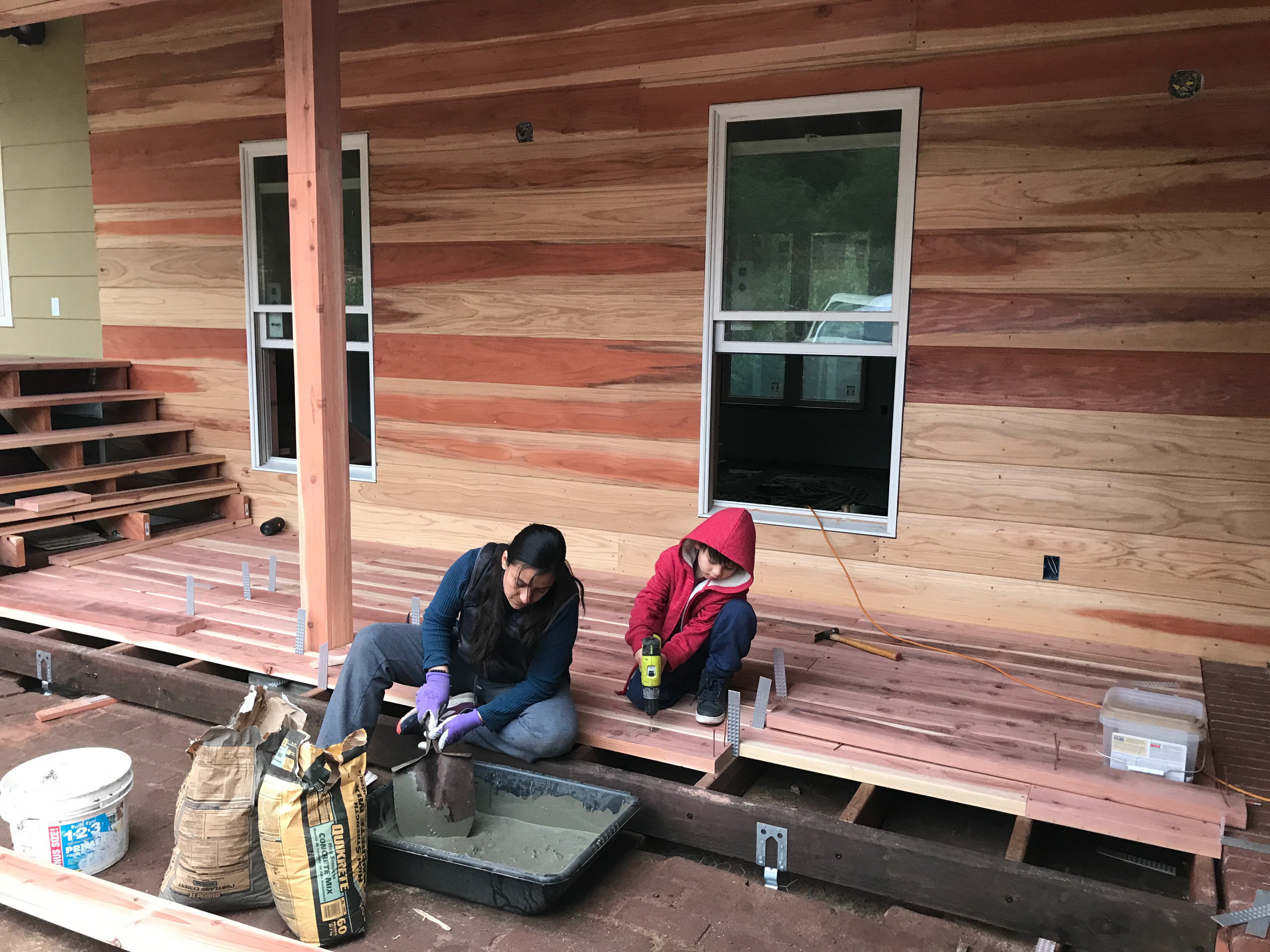 Lina and Solo building a redwood deck.