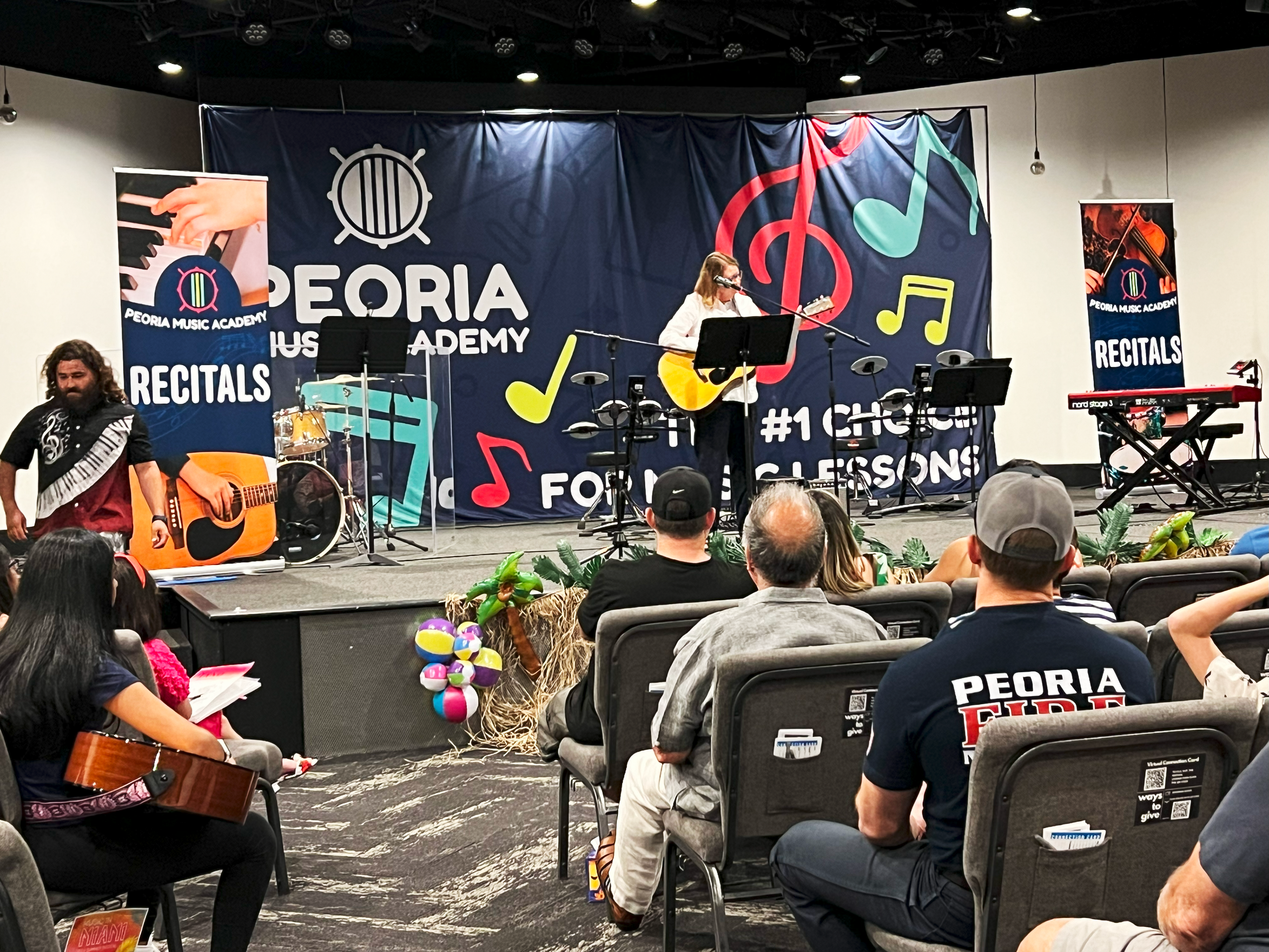 Large backdrop banner behind a performing guitarist.