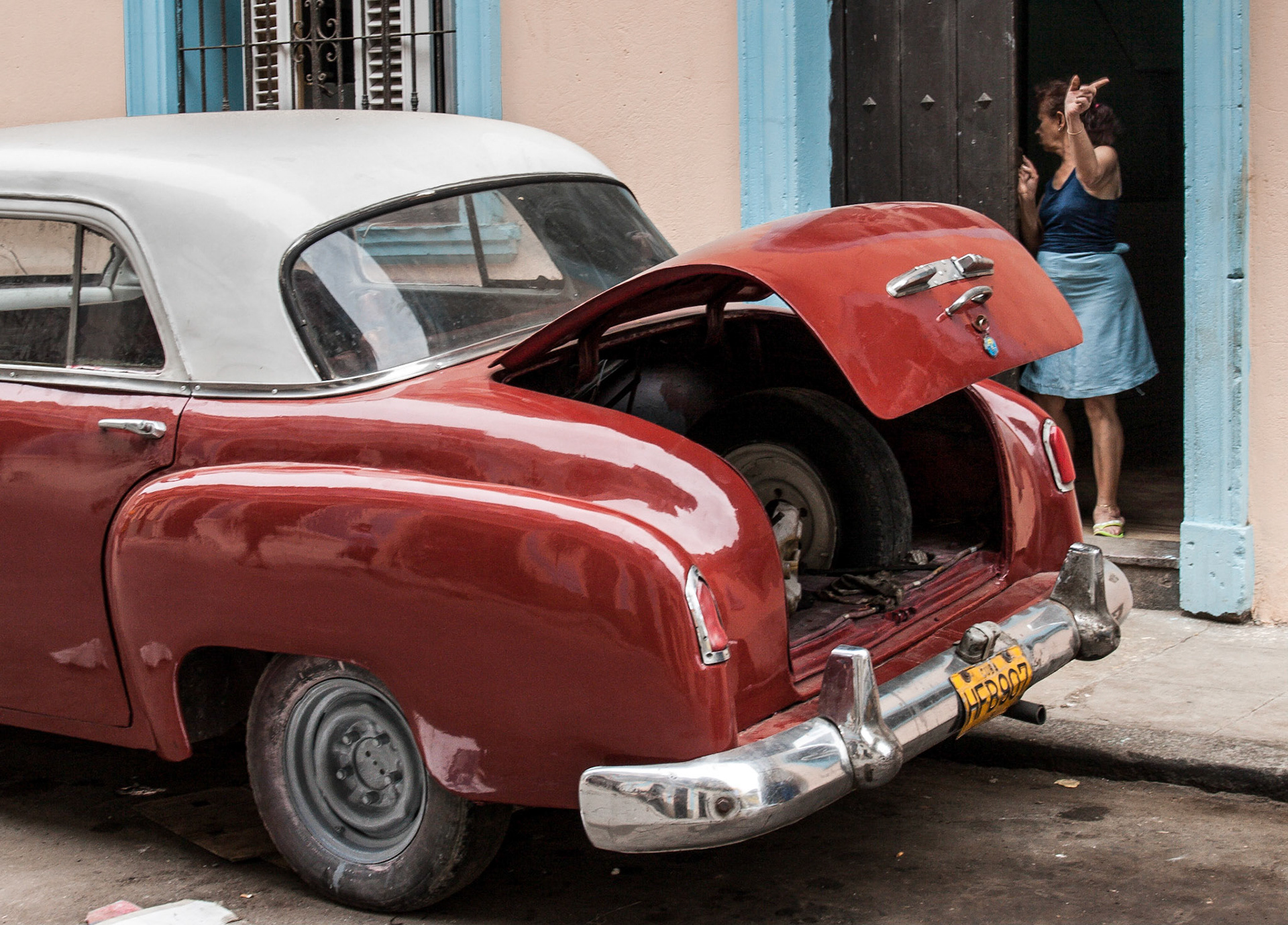 Red car in Havana with open trunk