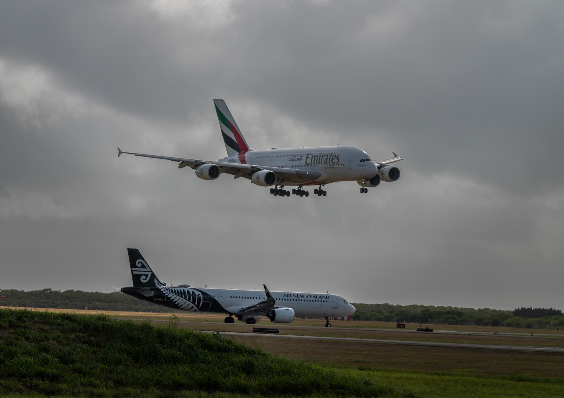 A380 landing / Air NZ waiting for takeoff