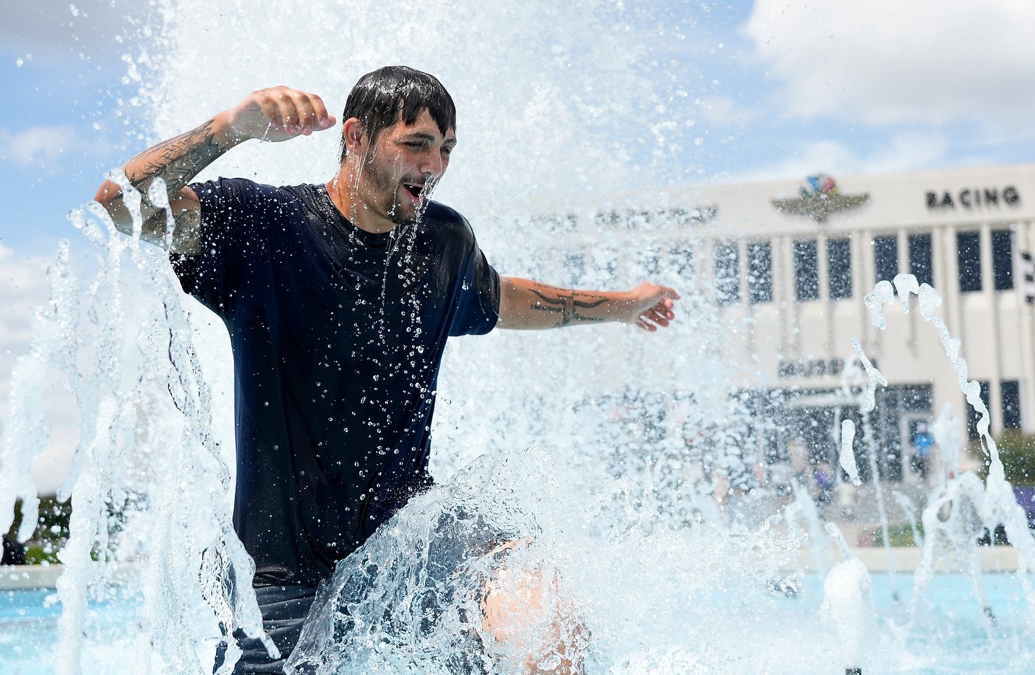 Ronnie Cartright of Baghdad, Ky., jumps through the Indianapolis Motor Speedway museum water fountain on Sunday, July 27, 2025, during the Brickyard 400 at Indianapolis Motor Speedway.