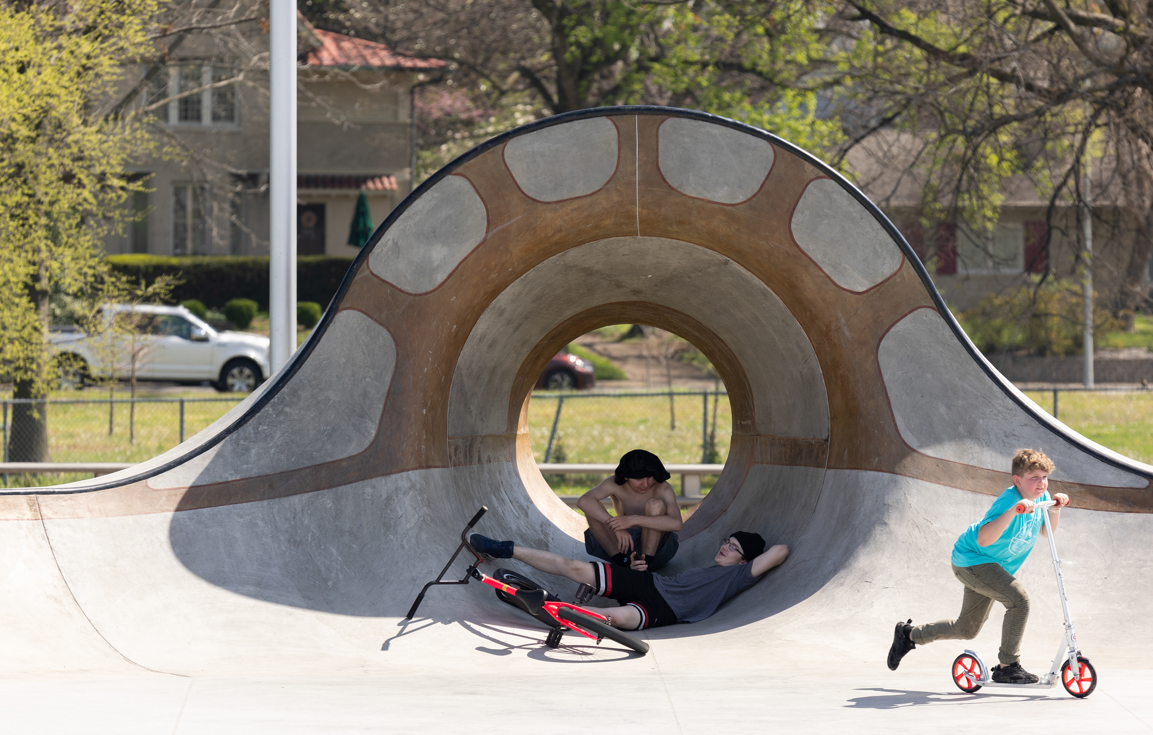 Evan Evans, 16, and Zayden Daniels, 13, sit in the shade of the Sunset Skatepark before the viewing of the total solar eclipse in downtown Evansville, Ind. on April 8, 2024. The pair had been riding in the riverfront skatepark while waiting for the eclipse to begin.