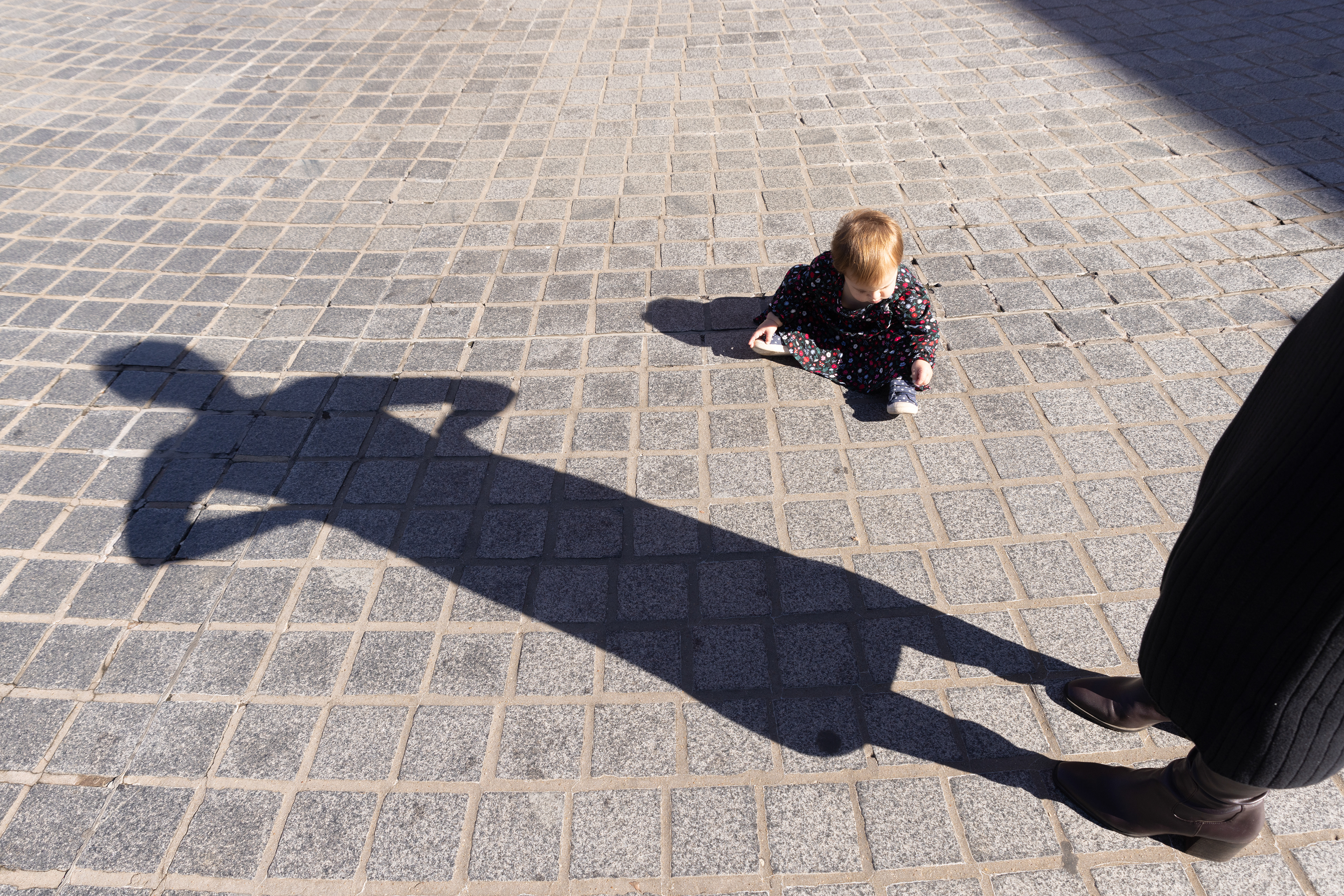 Wrinley Proctor, 1, plays on the ground while her mother, Sydney, watches over her at the Veterans Day ceremony held by Western Kentucky University ROTC at Guthrie Tower on Nov. 11, 2024.