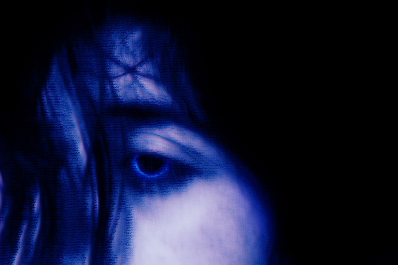 A close-up portrait of a person's face, black hair obscuring all facial features with the exception of an eye. The picture is tinted blue with a slight red hue as well. The person's eye is black, with only a deep blue ring visible where the iris would be.