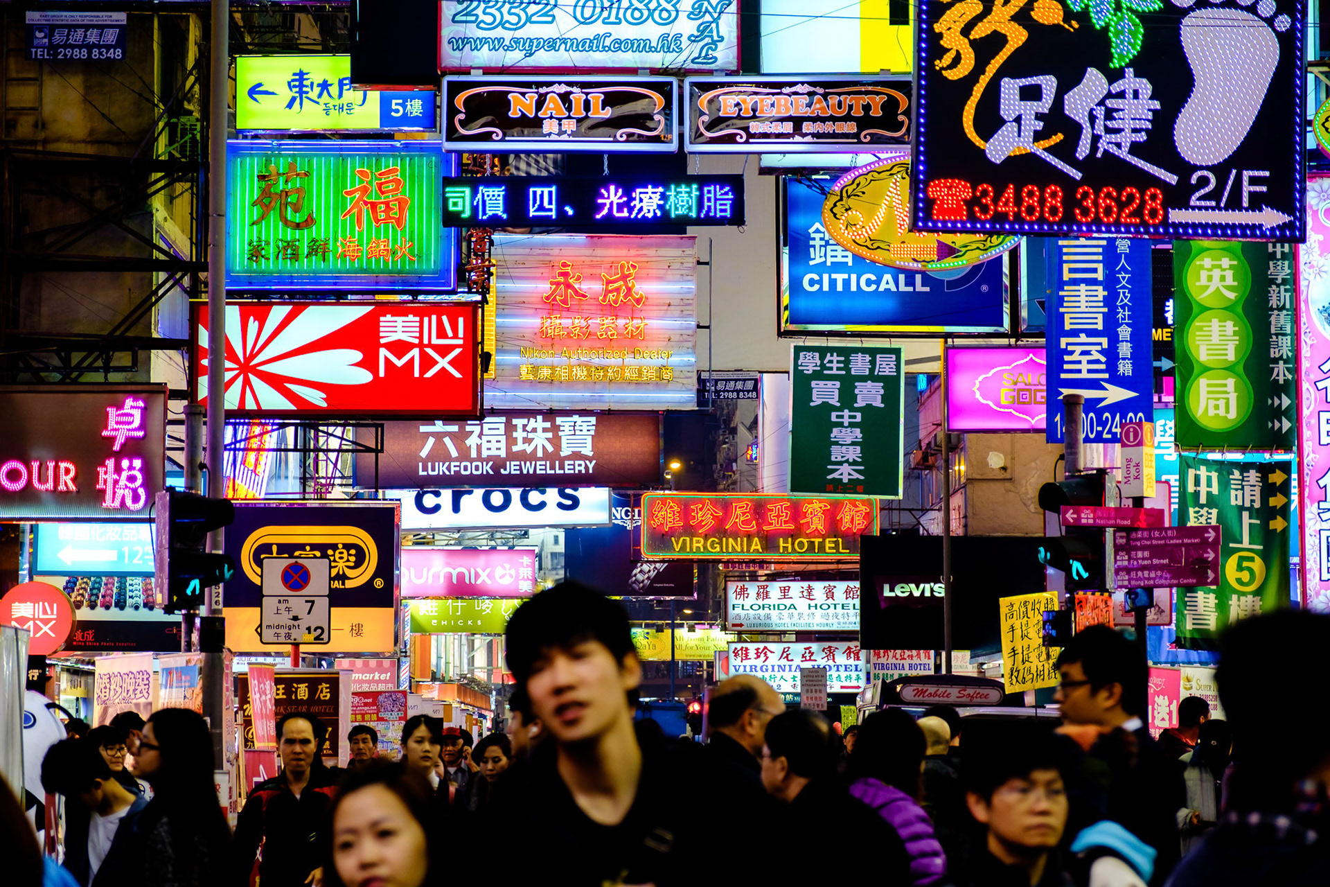 Mong Konk district in Hong Kong has some of the most dense streets in the world. people, advertising signs, buildings, shops and light live together in a hypnotic dance of shapes and colors.