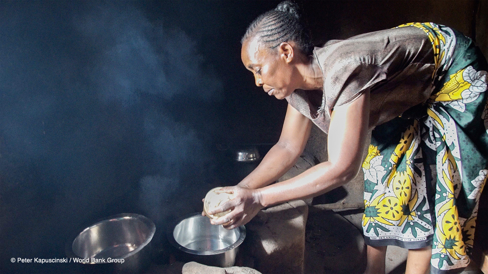Esther Atieno prepares dinner for her family in Kisumu, Kenya. Her recently installed jiko kisasa (firewood stove) uses less fuel than her previous stove. It’s also more efficient, giving her time to do bead work for extra income. Photo: Peter Kapuscinski / World Bank