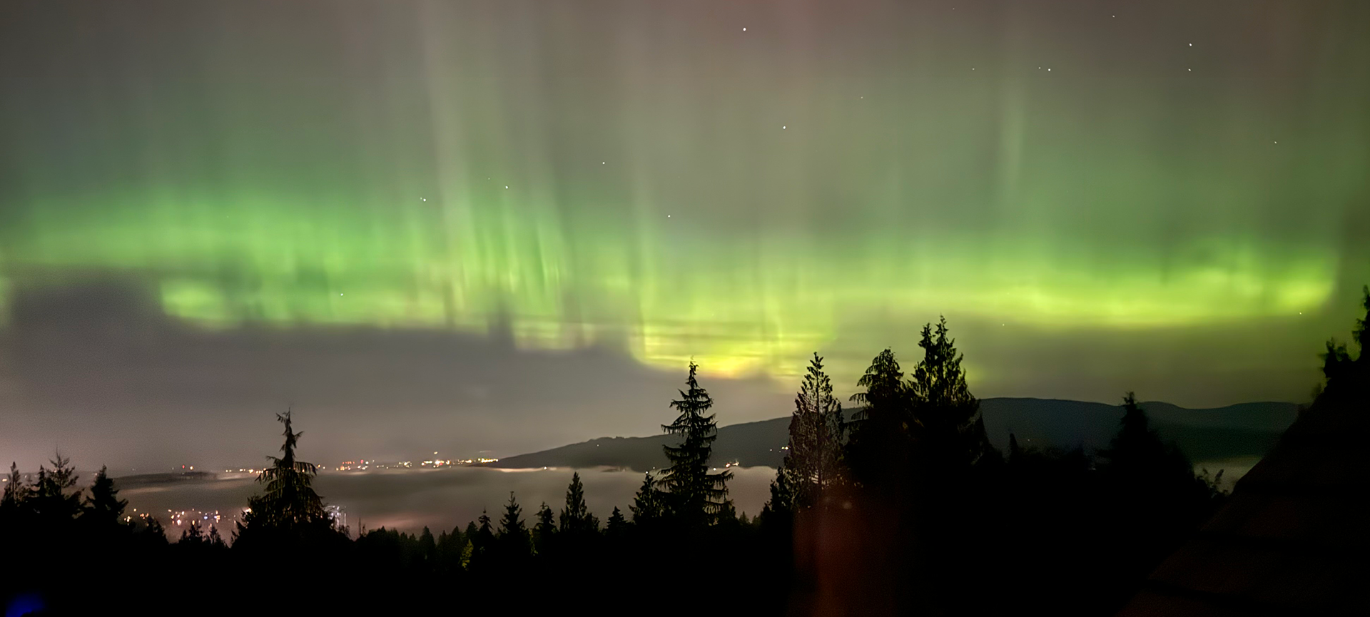 Photo Credit: Carol J Holland, Aurora Borealis looking North across a cloud covered Lake Whatcom, Oct 2024