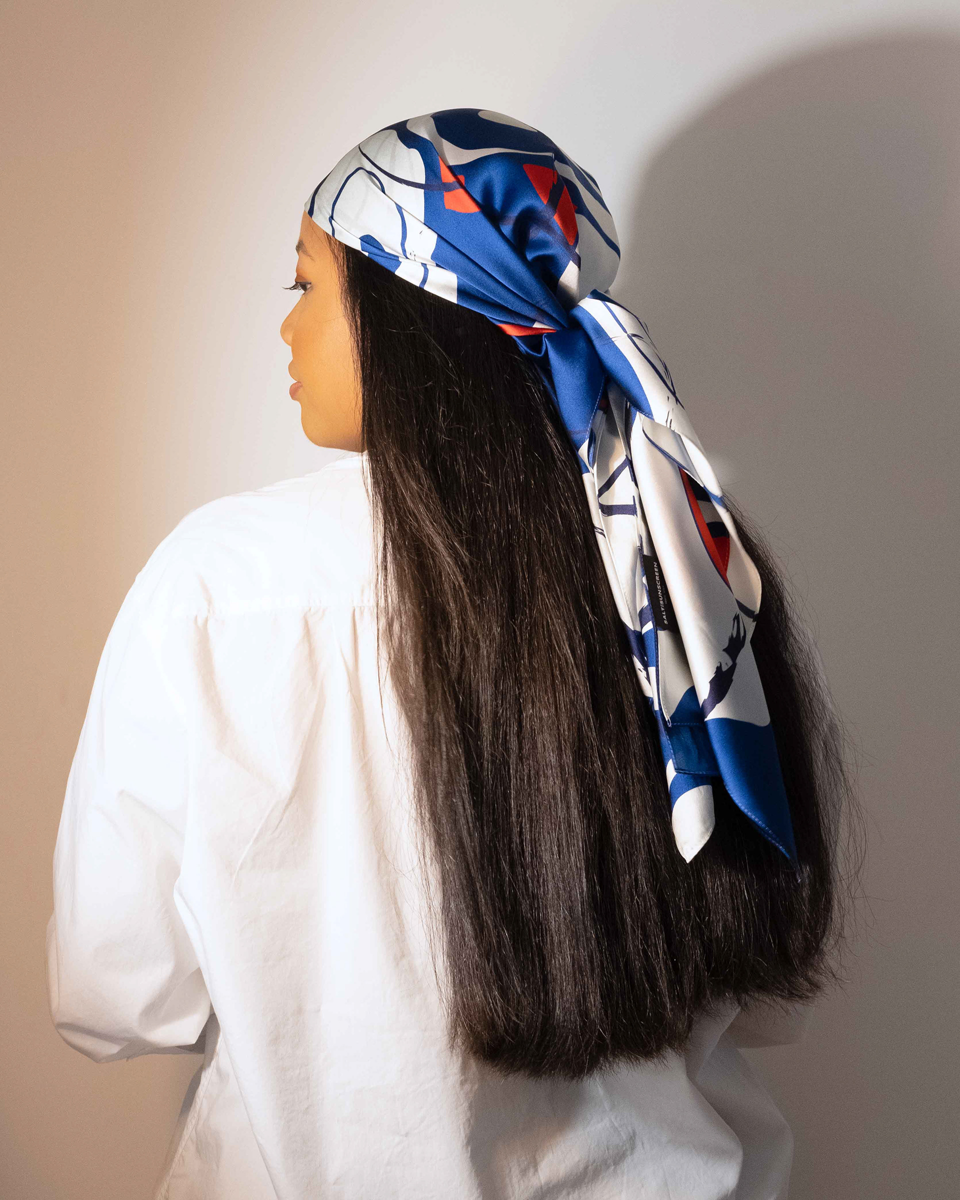 woman from behind wearing a printed silk scarf on her head