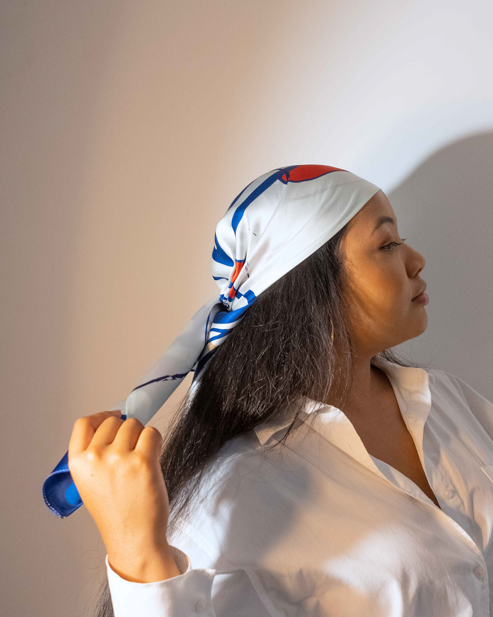 woman from the side wearing a printed silk scarf on her head