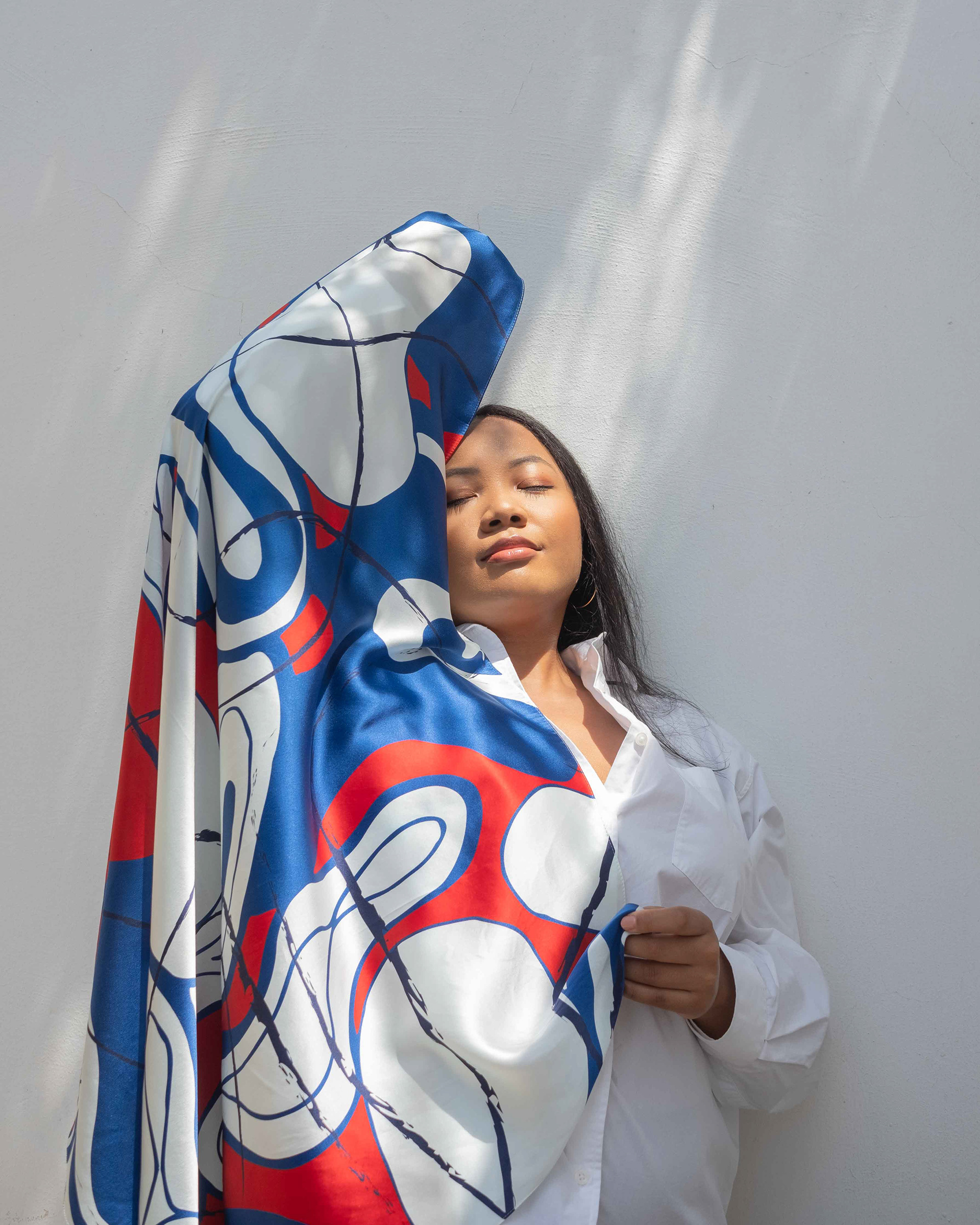 woman covering her body and face with a printed silk scarf