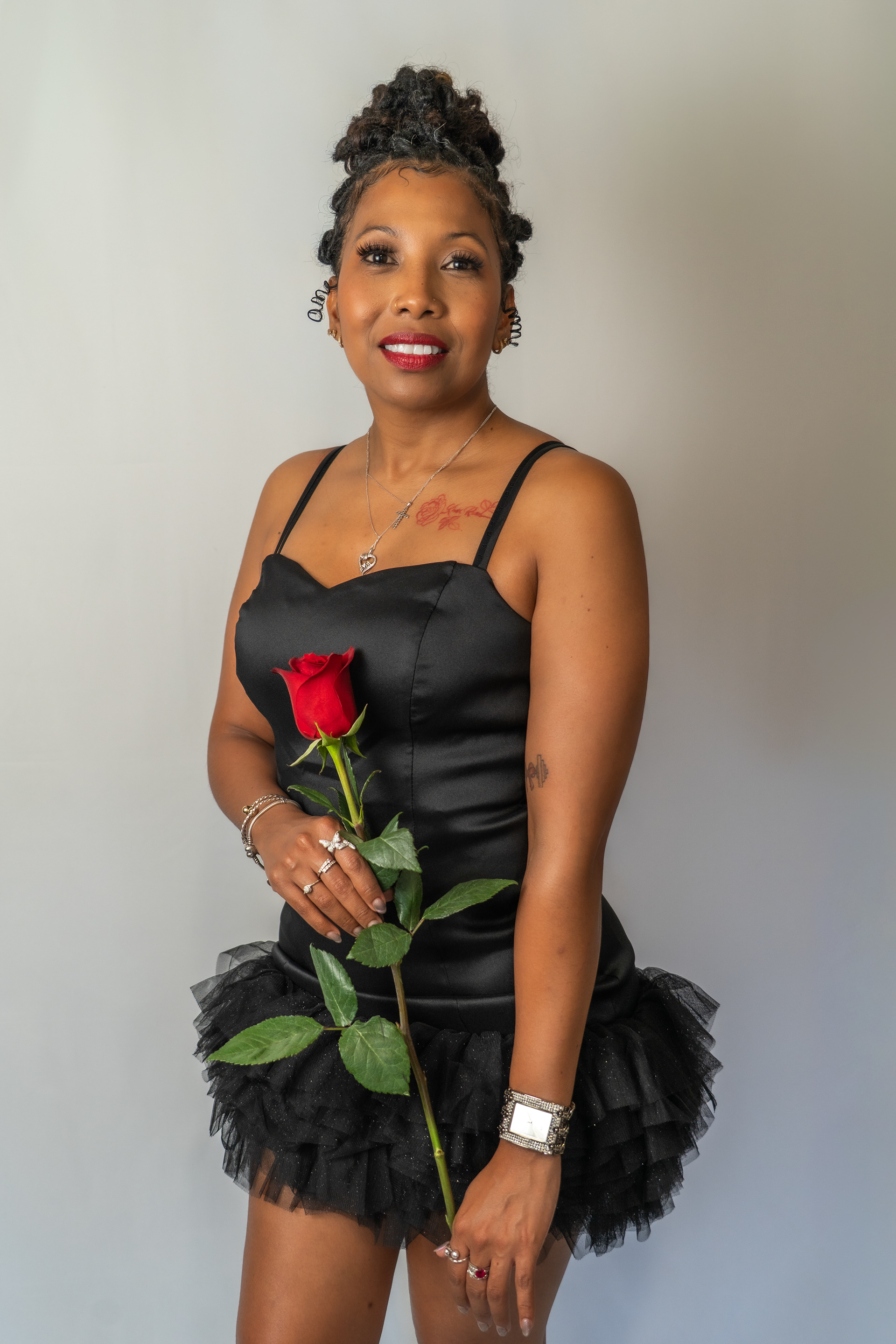 Woman holding rose, birthday shoot in studio.