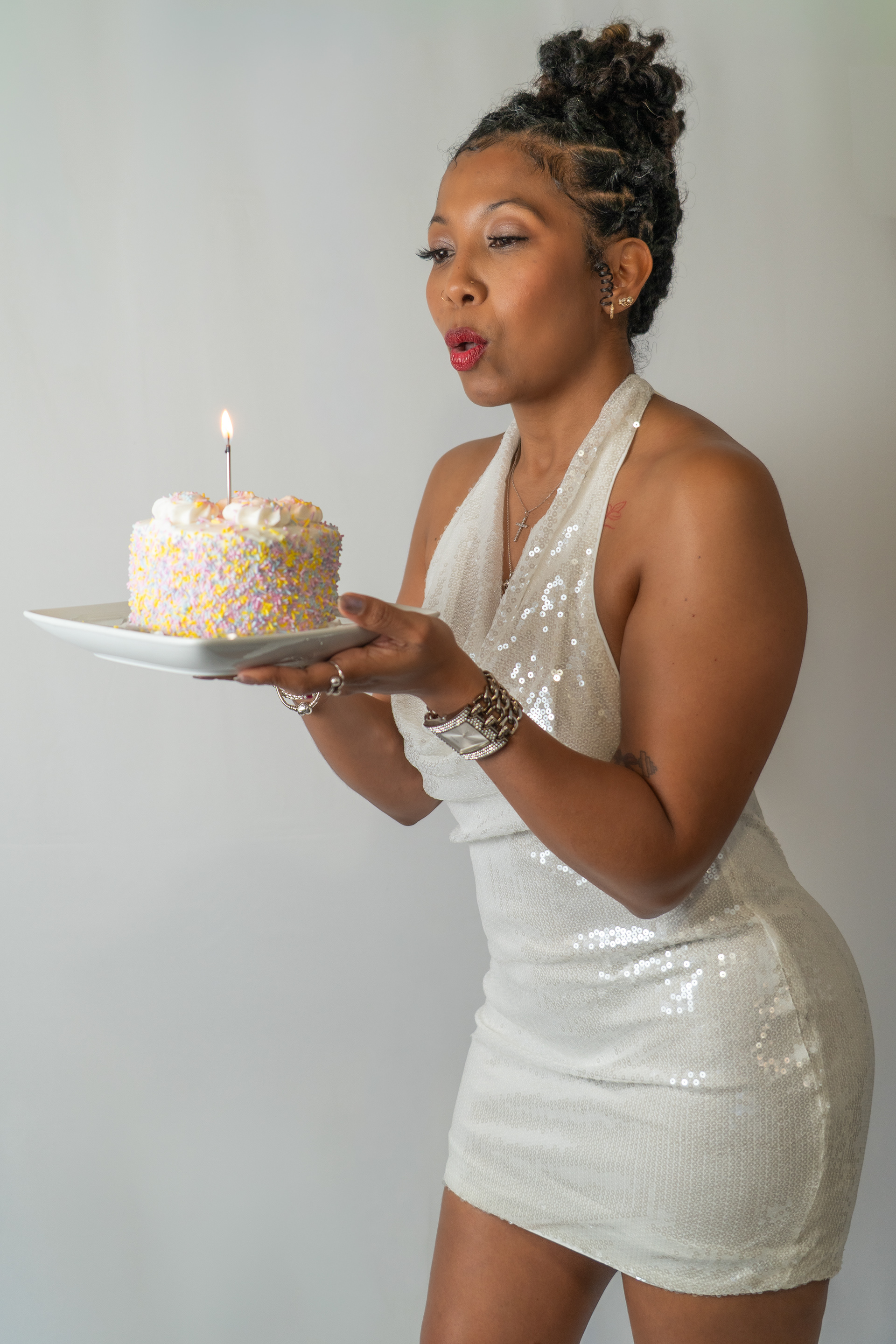 Woman blowing birthday cake in studio shoot