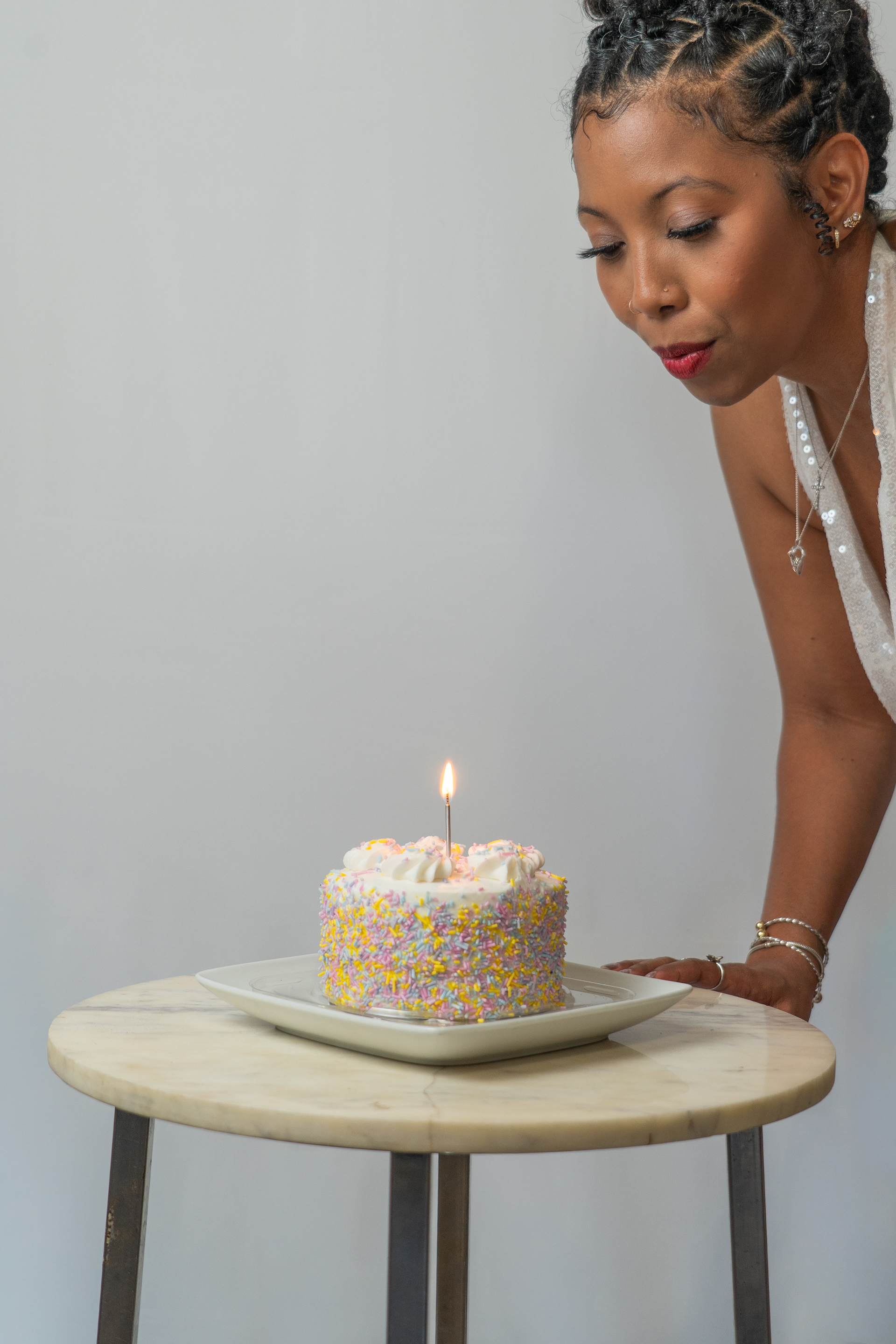 Woman blowing birthday cake in studio shoot