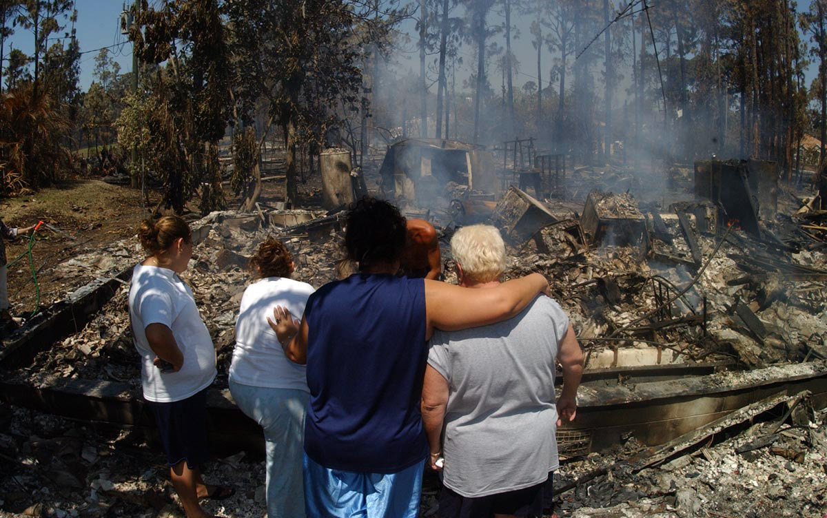 Palm Bay Fl - 5/13/2008 - Fuego forestal en Palm Bay - En la foto una familia que perdio su casa observan los restos de esta. Foto Pedro R. Berrios/ ENDO.