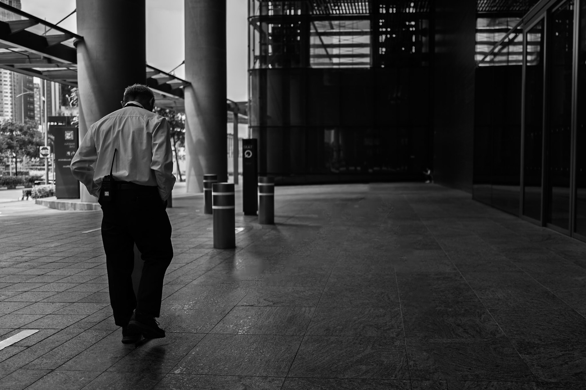A man walks head down through the empty colonnades of Singapore's financial district.