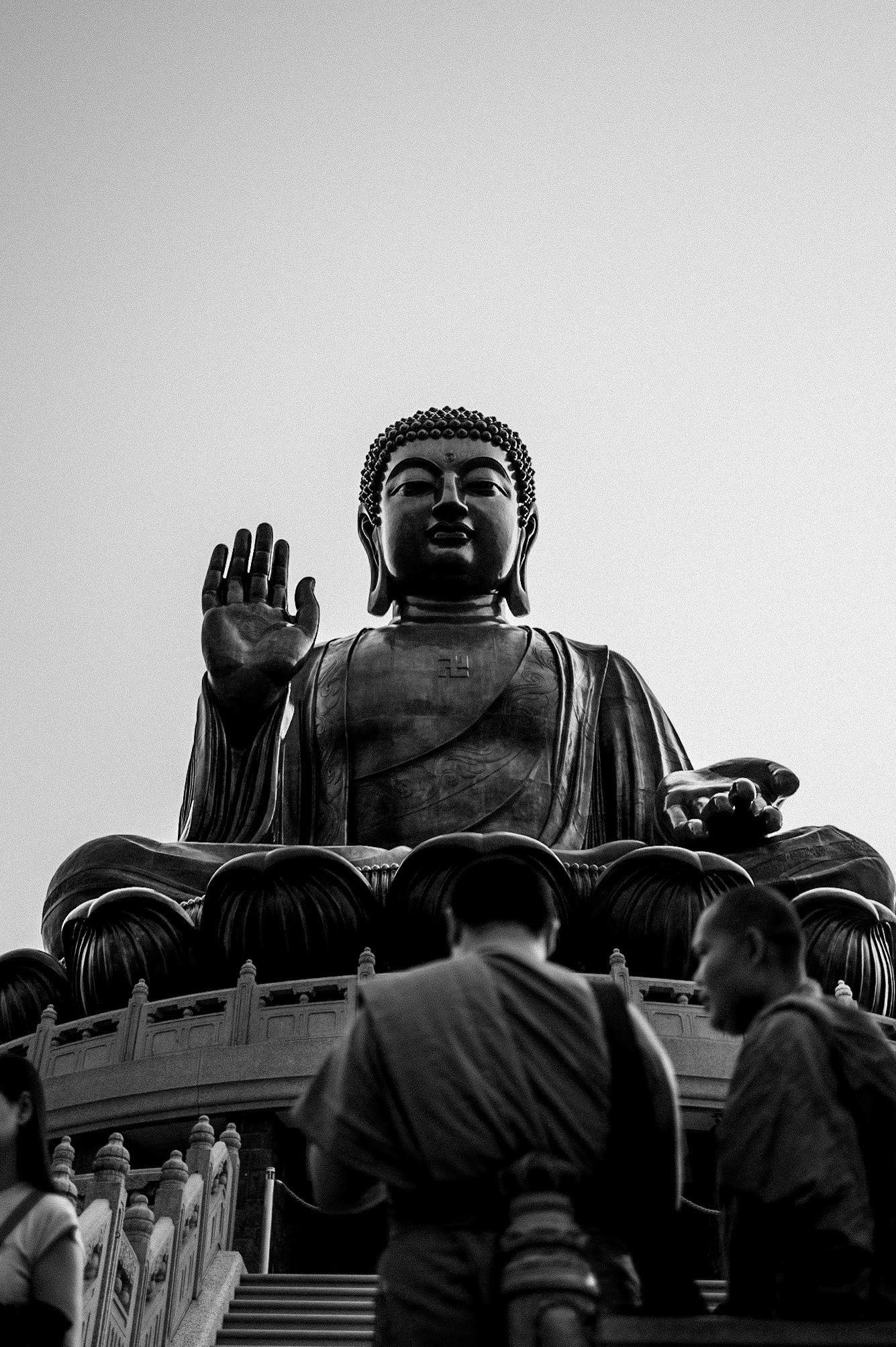 Beneath the Tian Tan Buddha, strangers move quietly through a space of reflection and stillness.