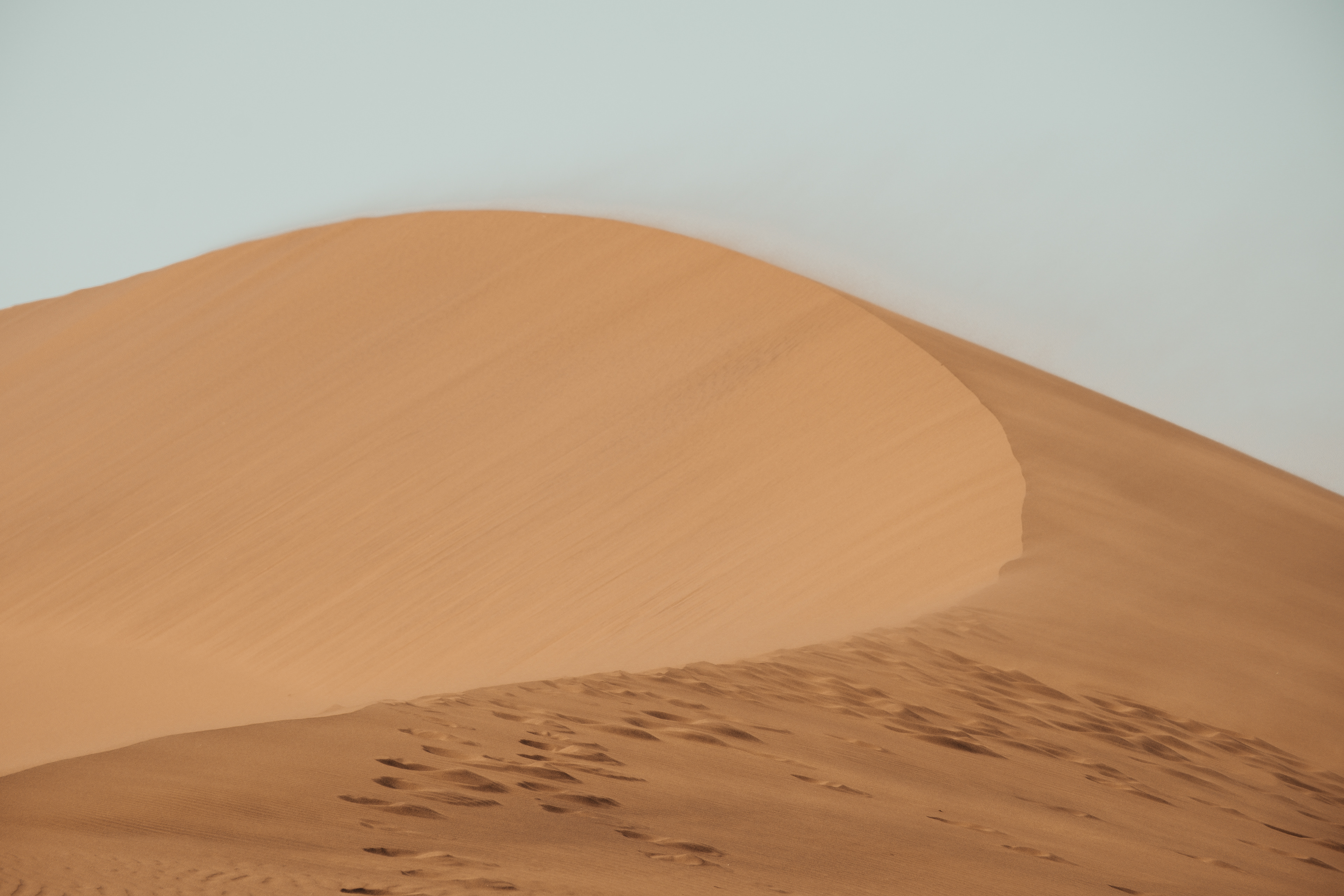 Huellas sobre la cresta de una duna de arena naranja en Namibia.