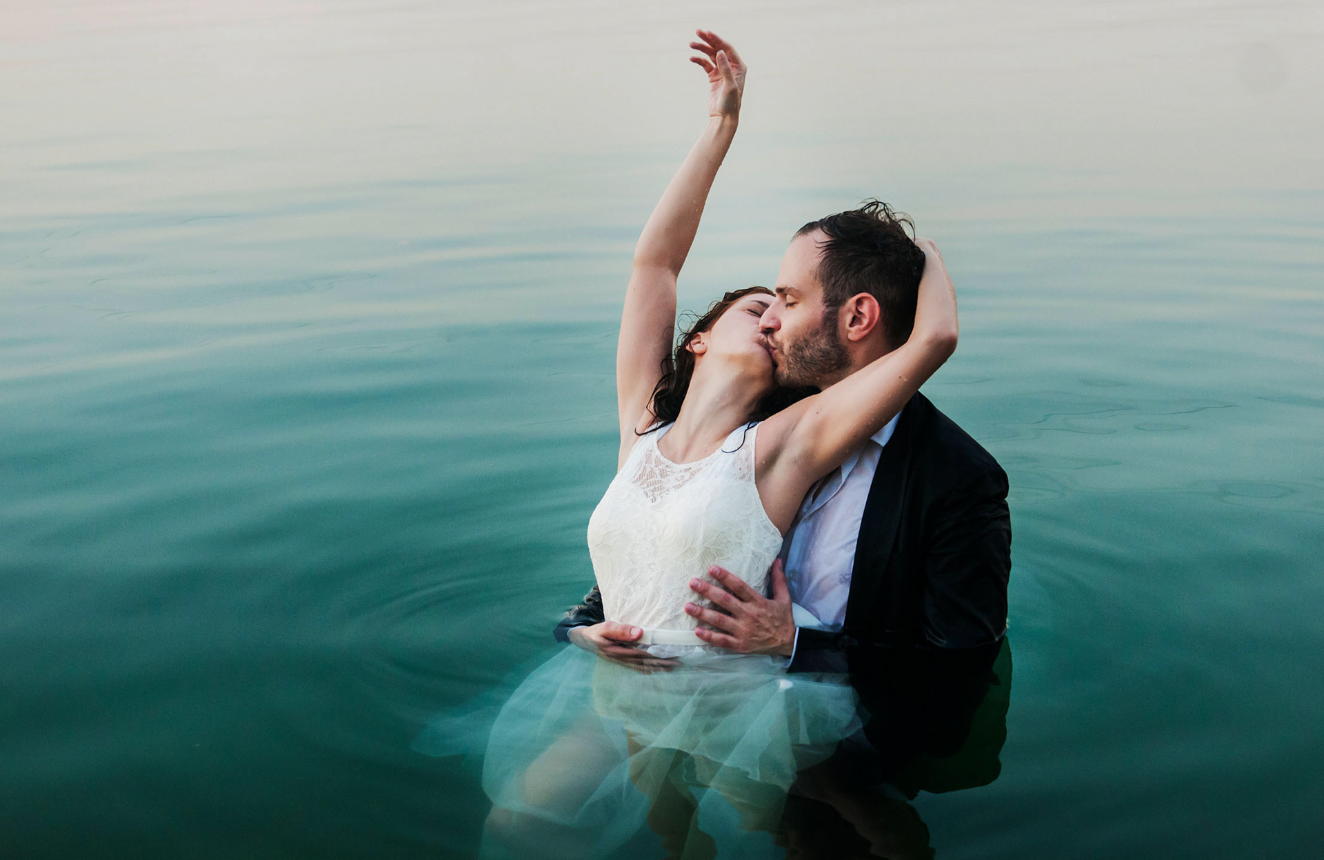 Magazin szerű, fekete-fehér esküvői fotó: a pár a vízben öleli egymást. Különleges, művészi esküvői fotózás Magyarországon. Fotó: Szeidl Marian.