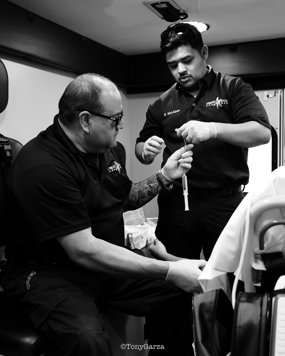 Eric helping Juan with the IV lock and saline flush.