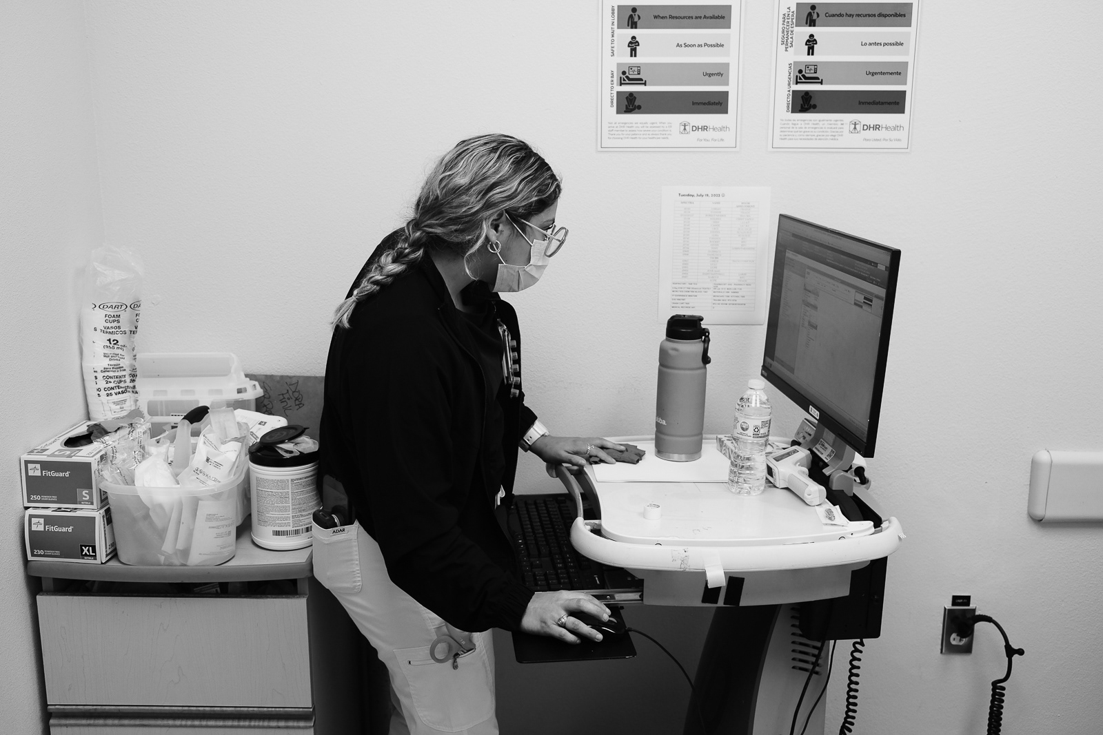 Nurse Tech Daisy checks the board of the lobby to help triage process patients.