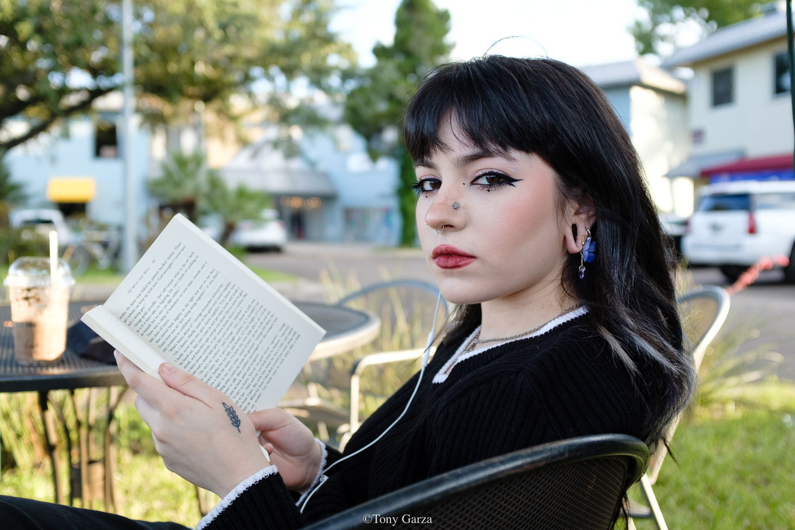 A young woman sits outside a coffee shop, reading a book, McAllen, Texas, June 2020. 
