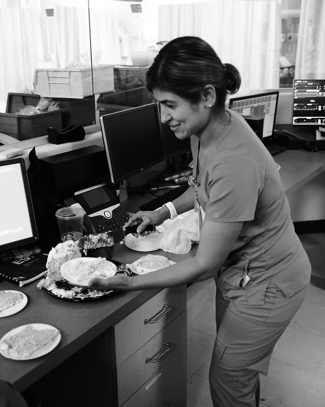 She cuts her farewell cake and prepares slices for the E.R. crew.