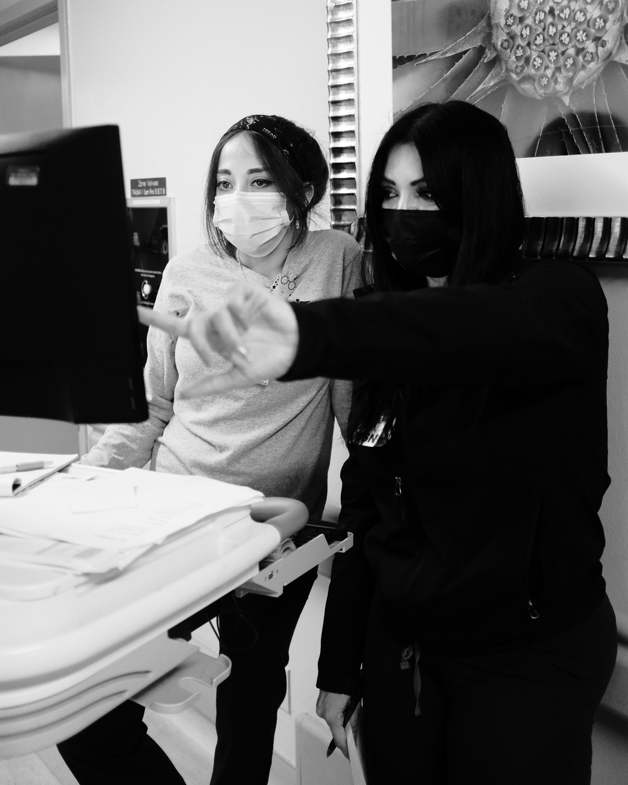 Vanessa and Erika, E.R. Nurses, helping each other manage the high flow of patients coming in at the end of shift.