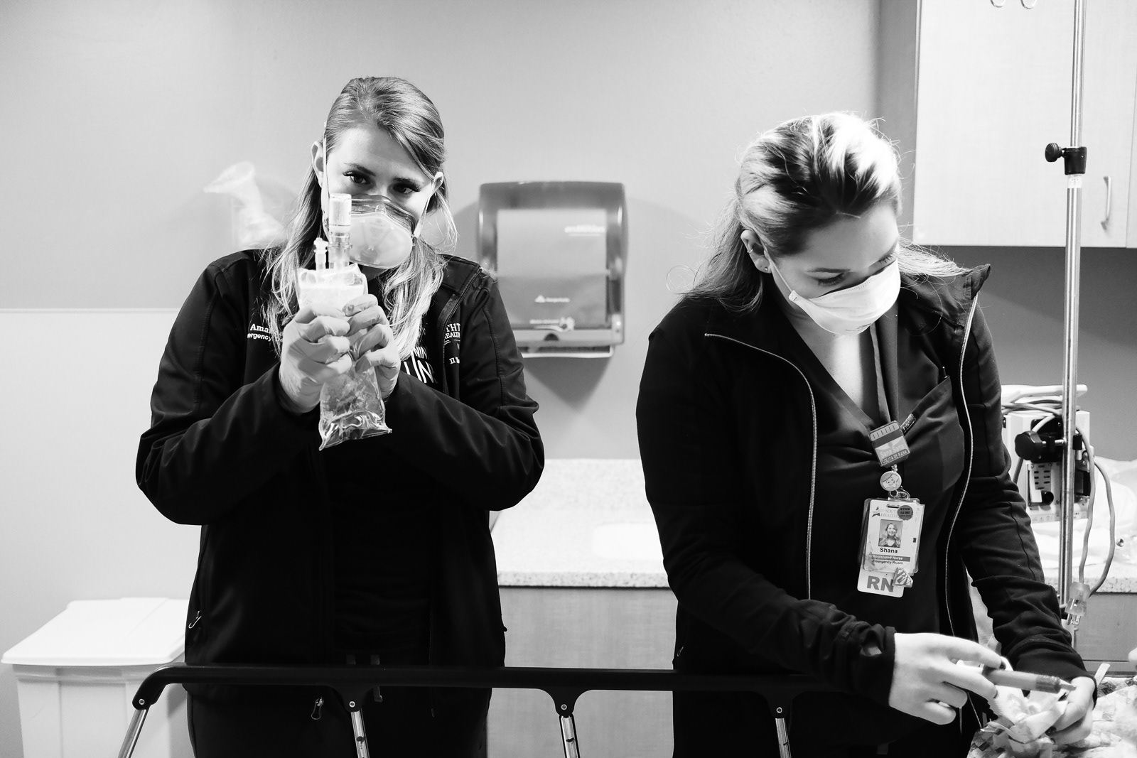 Amanda, RN, (left) stays pass her shift, despite a busty night, to help Shana, RN, with a sick patient.