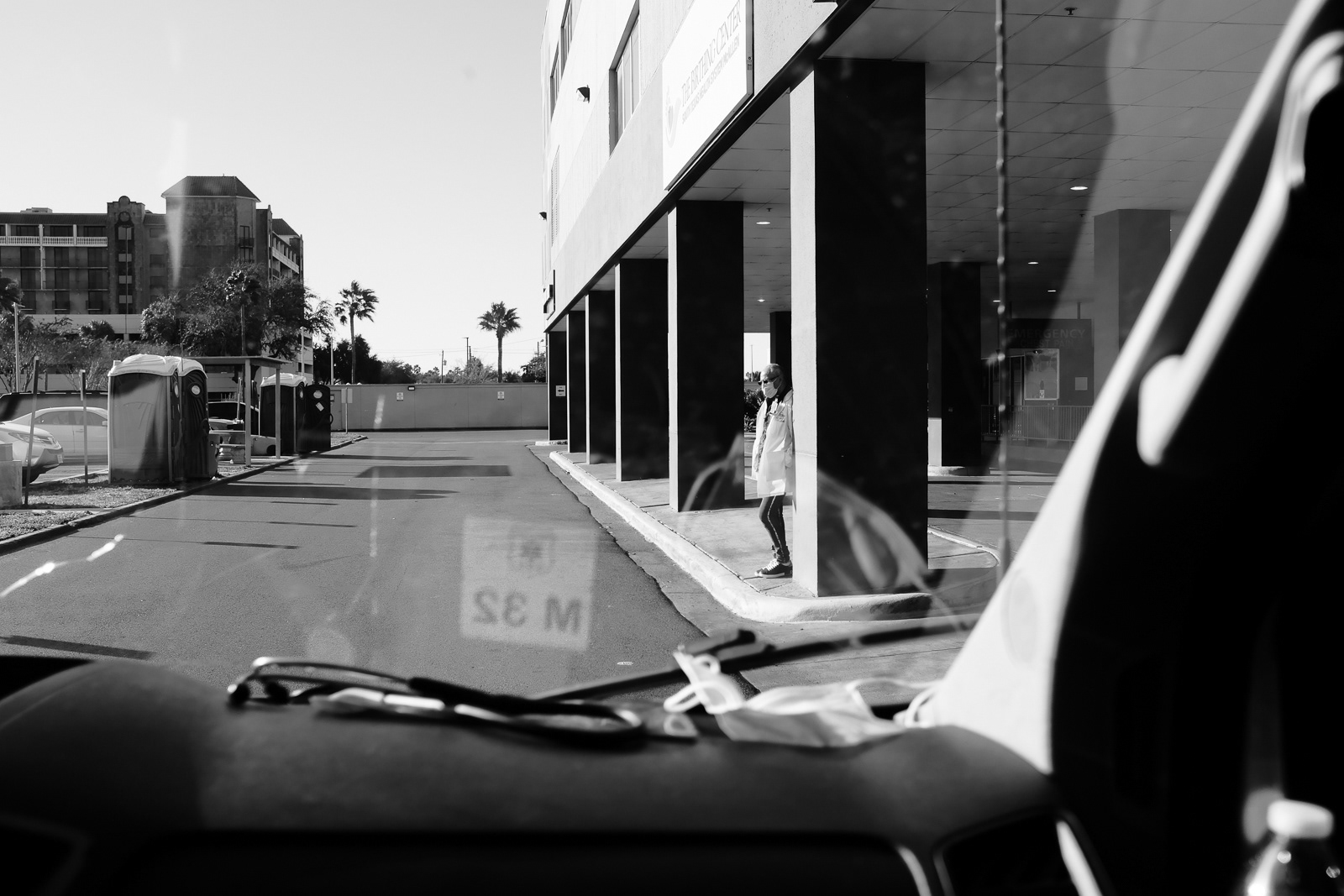 A physician, waiting and in deep thought outside of the hospital. Whats wrong Doc?