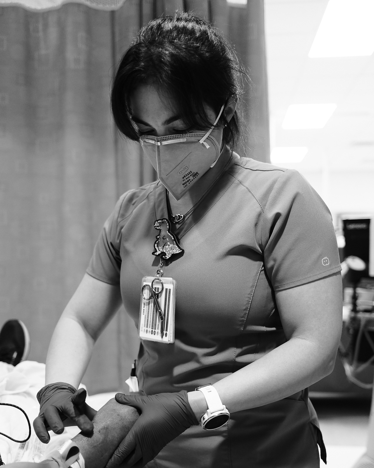 Diana looks for a vein to start a second line on a patient.