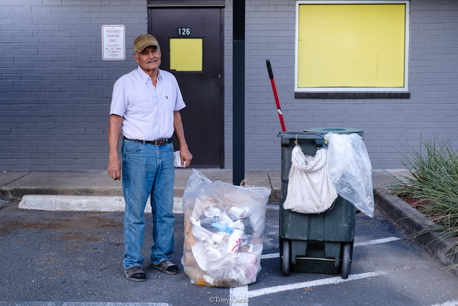 An elderly man collecting trash from the trash bins, McAllen, Texas, July 2020.