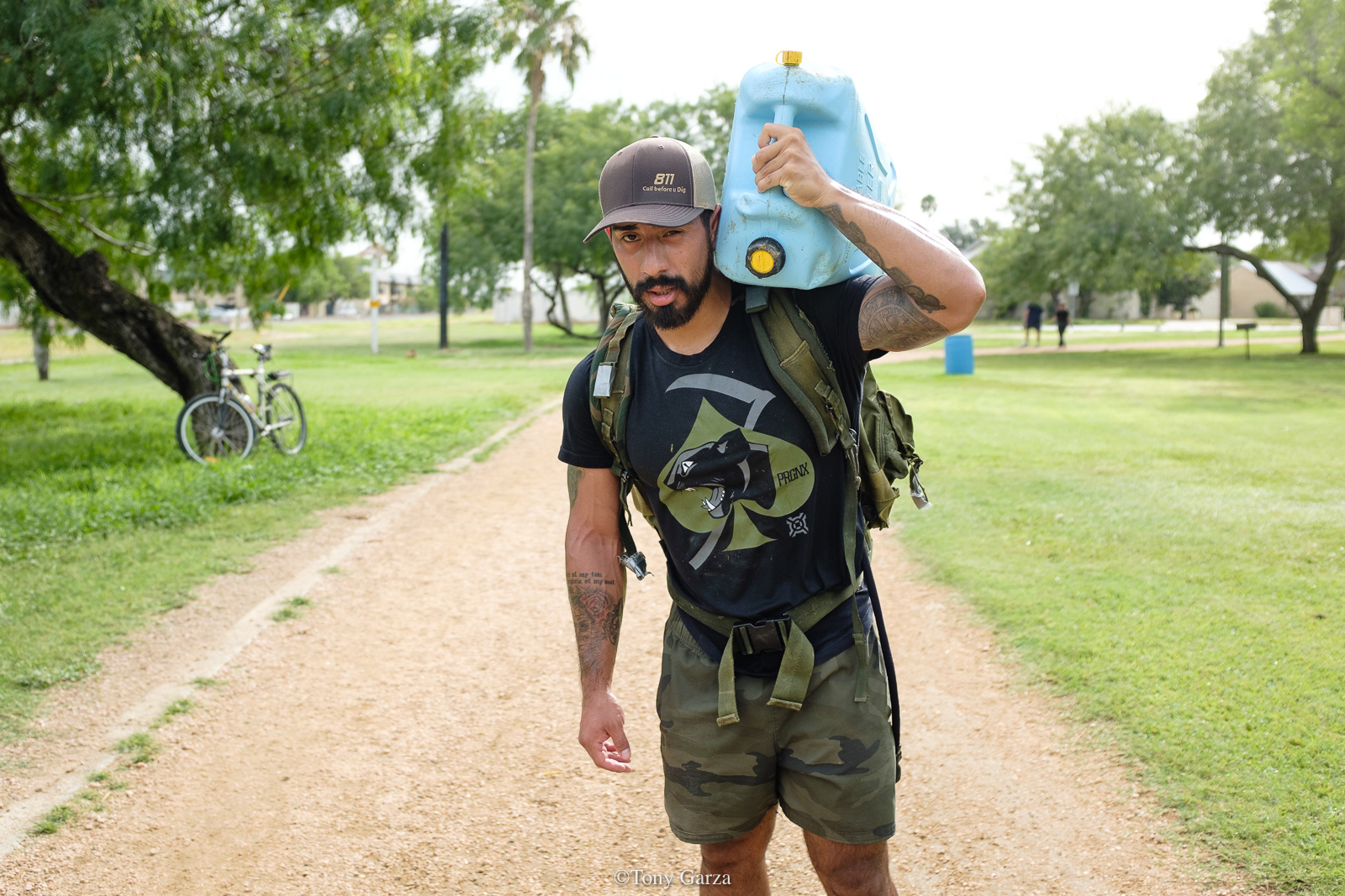 A man walks with a backpack and water jug in preparation for BORTAC, McAllen, Texas, June 2020.