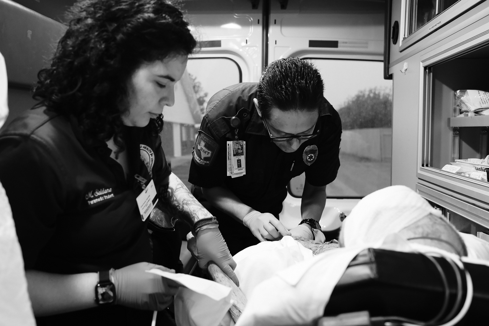 A team of 3 helping a pateint with an arterial bleed to his head.