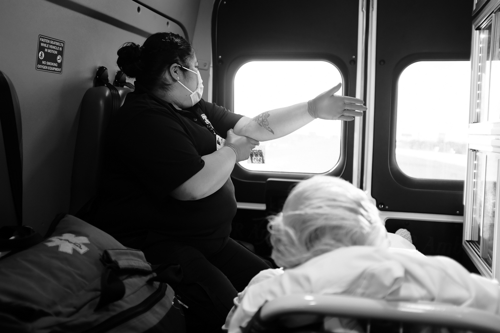 She blocks the sun from hitting the patients face with her arm.