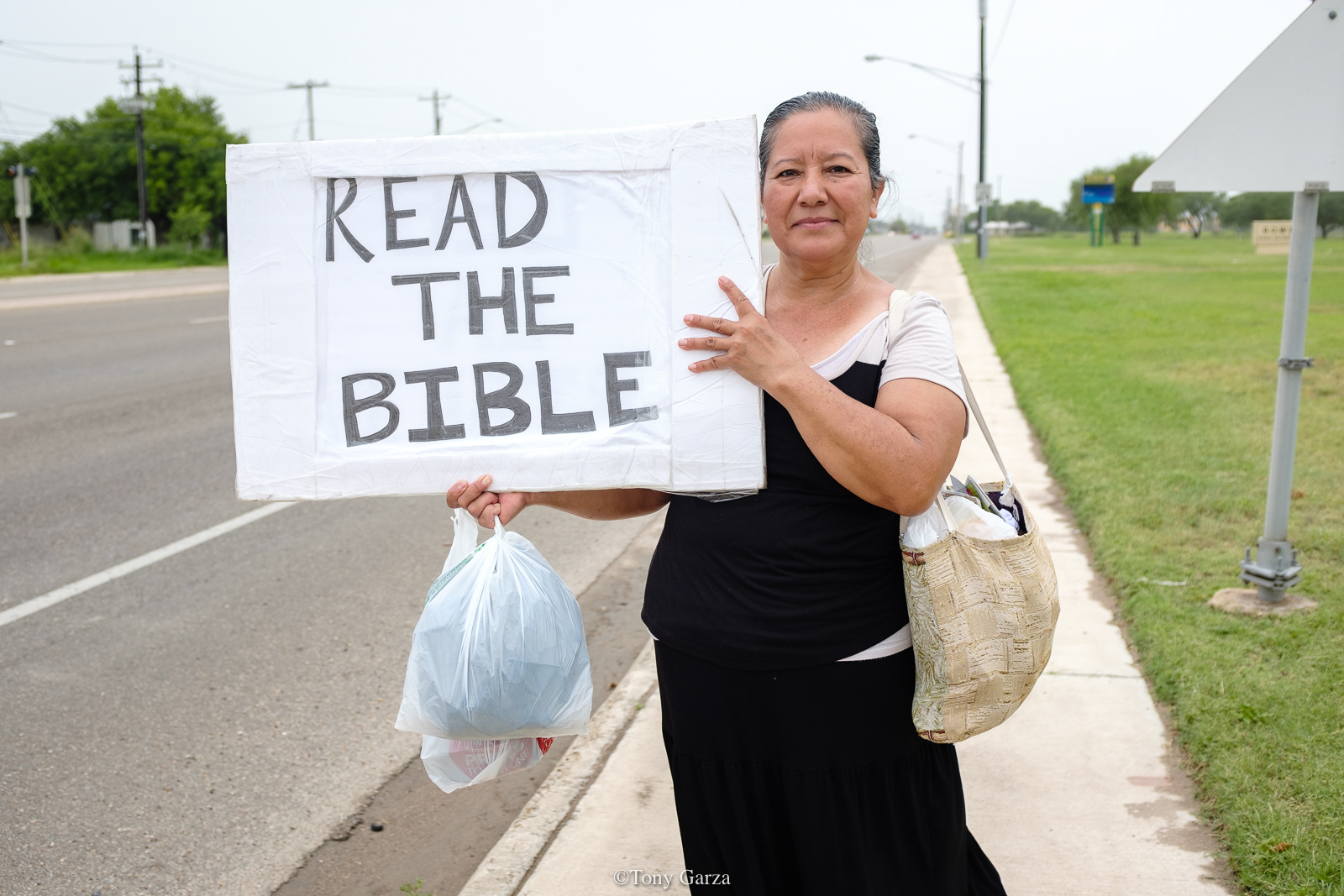 An elderly woman walks the streets with her message, McAllen, Texas, June 2020.